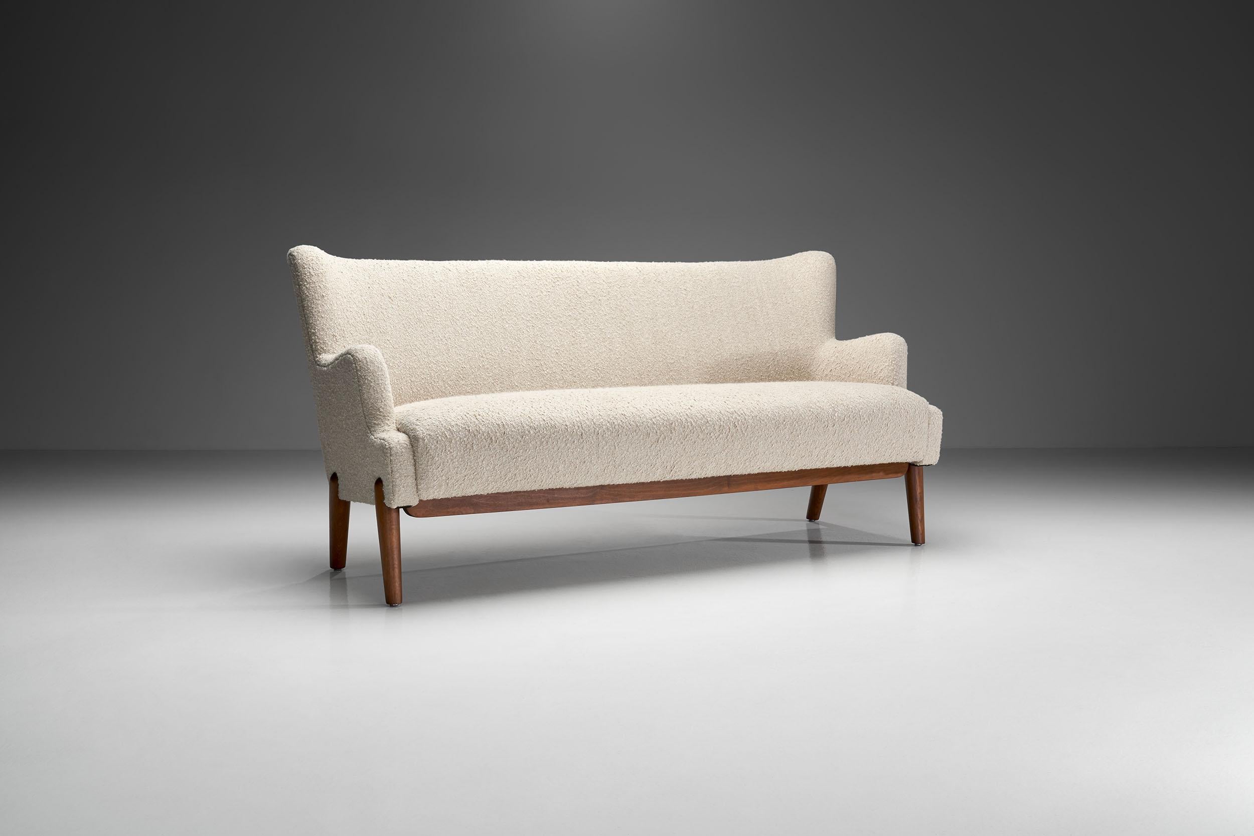 This three-seater sofa has the best characteristics of Danish mid-century modern design. Its comfort and delicate design elements make this three-seater the most coveted work of Eva and Nils Koppel.

The stair-like gradation of the armrests starts