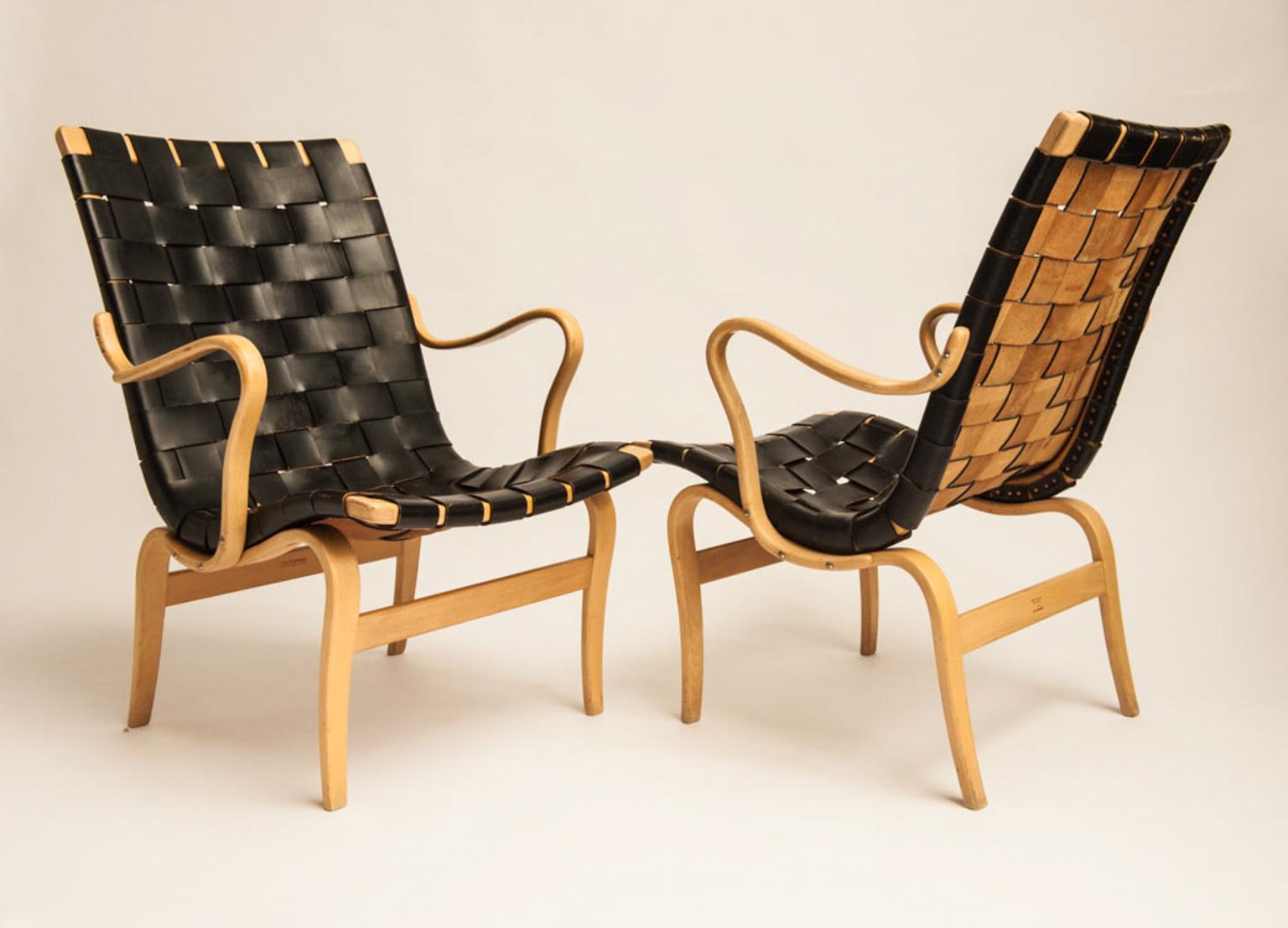 The set of two Eva Lounge chairs is designed by Bruno Mathsson in 1935, and produced by company Karl Mathsson in the 1960s. They are made from molded beech with saddle girth in black harness leather.