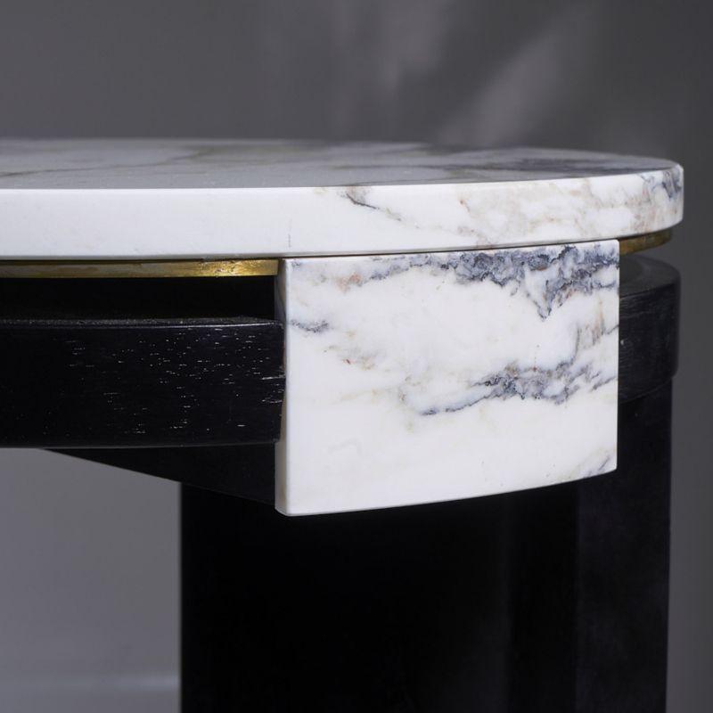 A round bedside table in ebonized varnished walnut, central element covered in marble Breccia Medicea, top in marble Breccia Medicea with perimeter wire in brass. Designed by Atelier Avanzi.
 