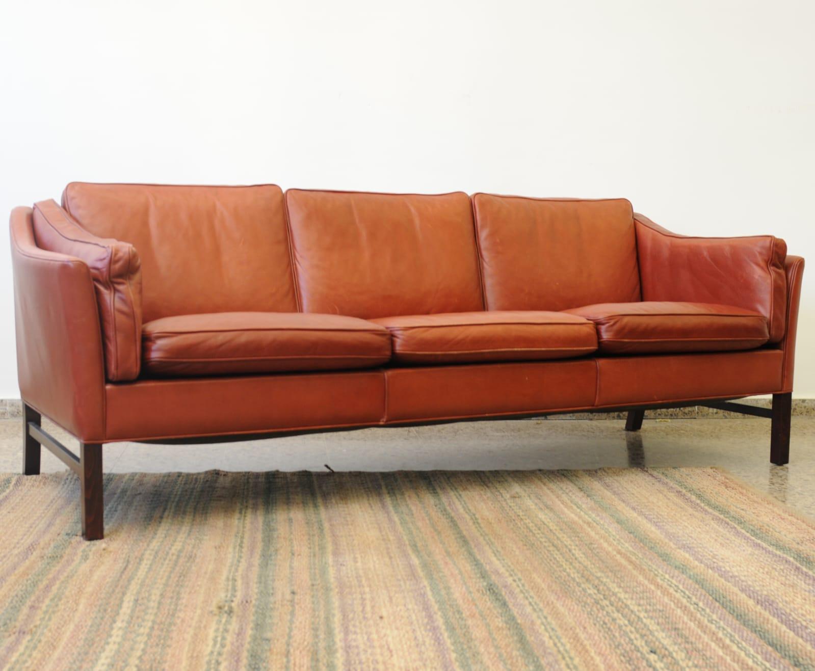 Vintage By Dreisitzer EVA Modell Büffelleder Sofa, Design von Stouby Polster Møbelfabrik aus Dänemark ca. Mitte der 1960er Jahre. 

Das Gestell besteht aus massivem Buchenholz, das mit einer starken Lederauflage verbunden ist, mit gepolsterten