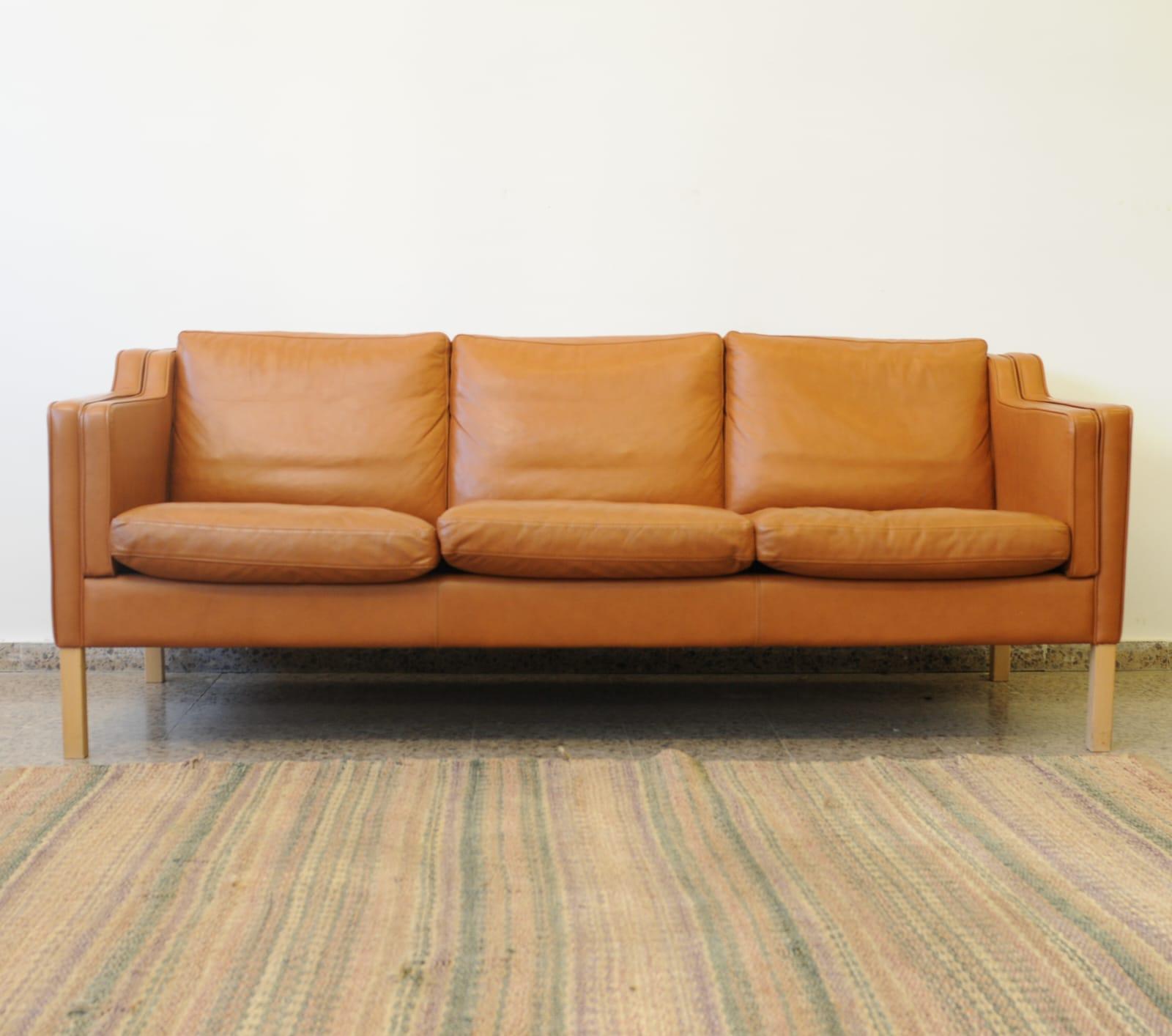 Vintage Three-seater EVA model cognac leather sofa, design by Stouby Polster Møbelfabrik from Denmark circa mid 1960s. 

The structure is in solid beech wood, joined by a strong leather support, with padded foam cushions in leather upholstery.