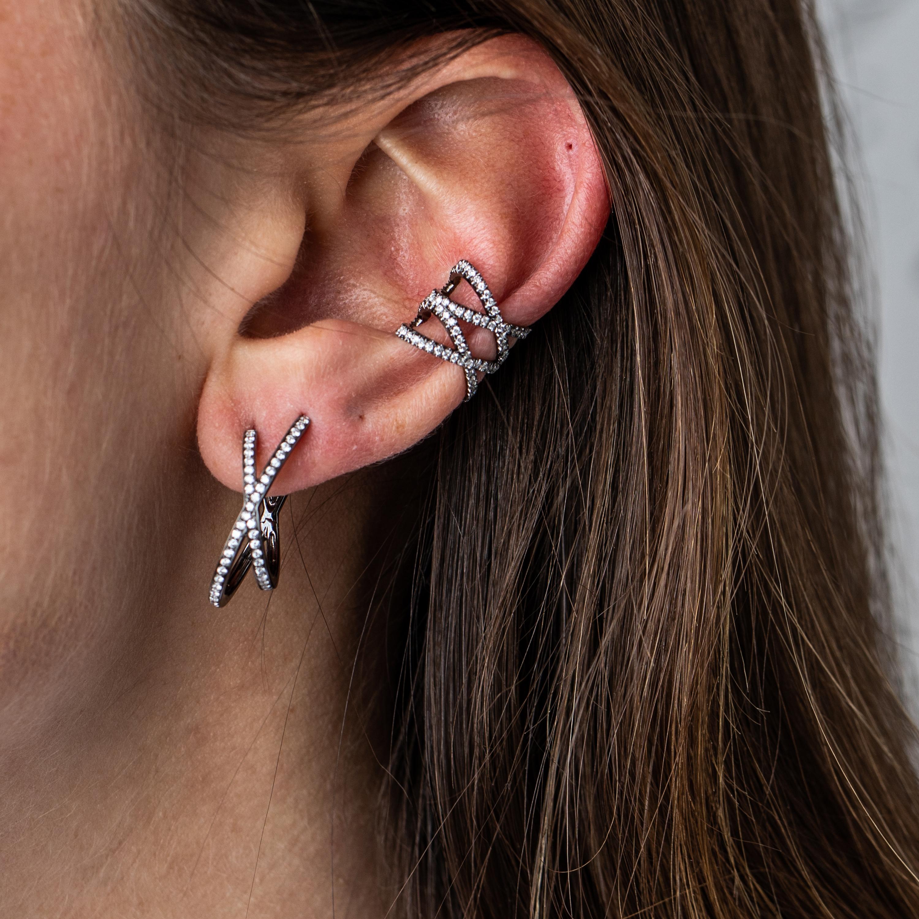 18K Blackened White Gold White Diamonds - Medium Orbit Hoops

The Orbit Hoops continue to evolve the iconic X shape on the ear, wrapping around to create the illusion that they go through two piercings.  The hoops are hinged in the center of the