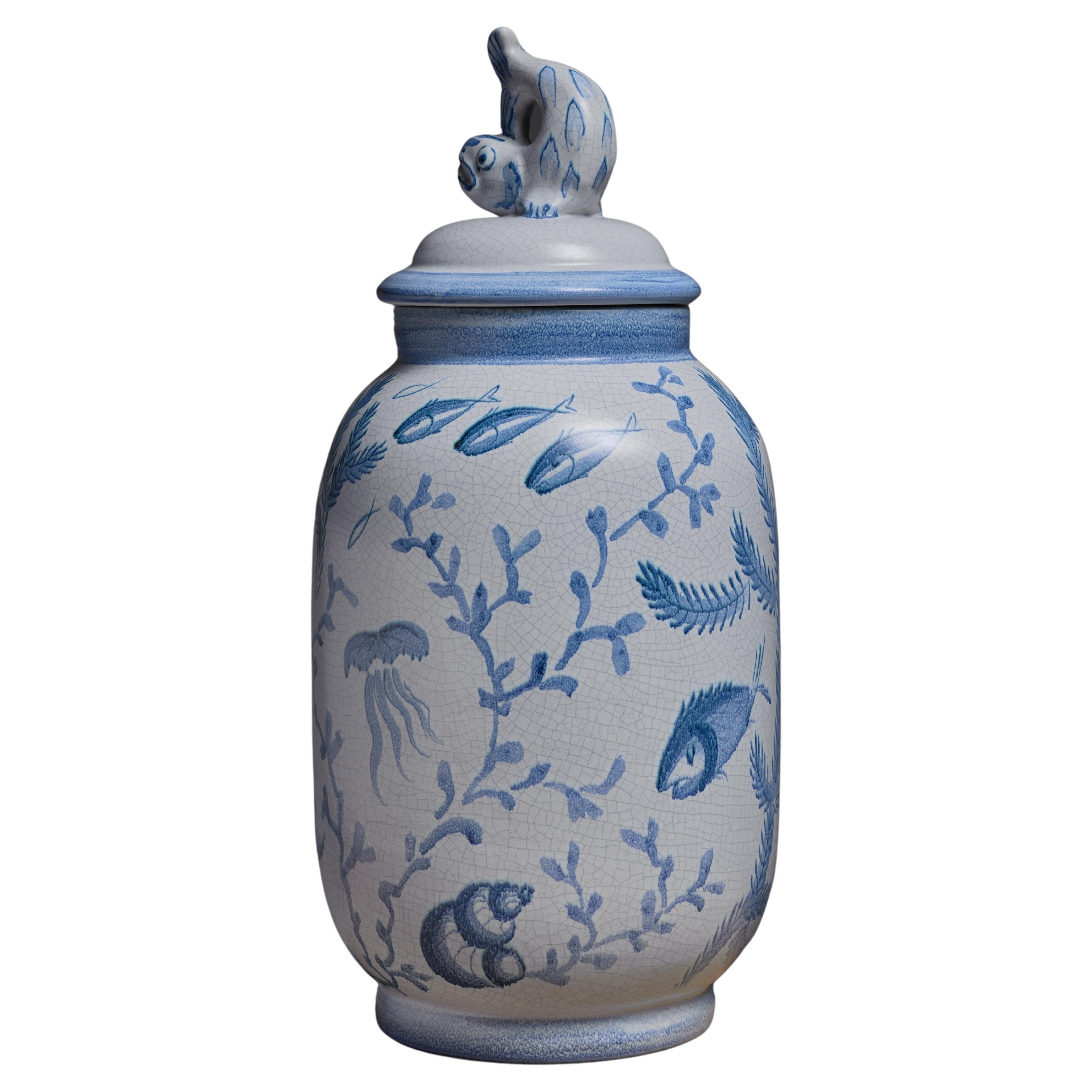 A ceramic vase by Eva Jancke-Bjork for Bo Fajans, Sweden. The vase has blue decorations of fish, algae etc. The lid is decorated with a dolphin figure.
The vase is signed by Jancke-Bjork and Bo Fajans underneath.

Eva Jancke-Bjork (1882-1981) was