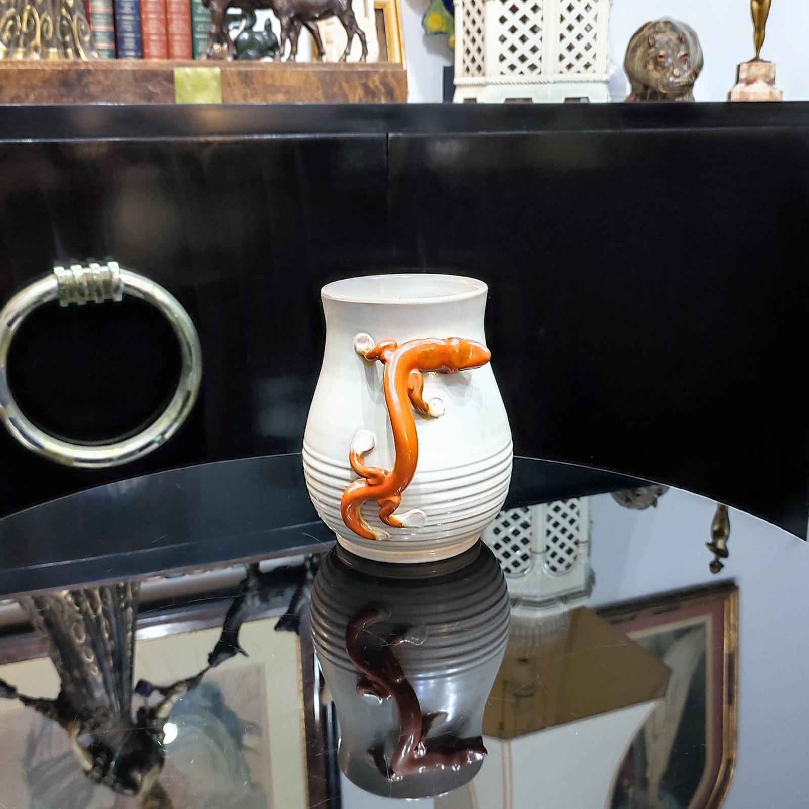Vase en faïence Salamandre, conçu par Eva Jancke-Björk, BO Fajans Gefle, Suède, années 1920.
Le vase en faïence a été décoré d'un lézard rouge orangé sur fond beige, qui peut servir d'anse. 
Hauteur 18 cm.
Il est en bon état général, avec de petits