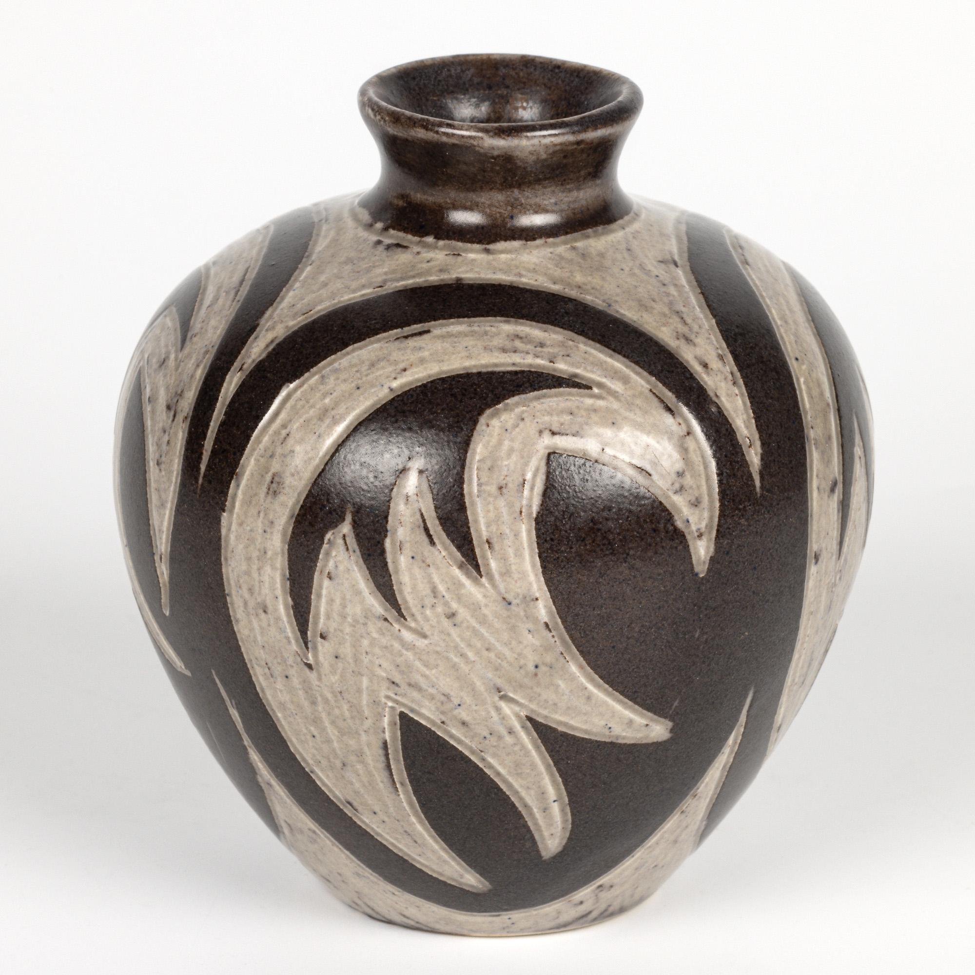 A stunning Danish mid-century sgraffito art pottery vase by Evan & Johannes Andersen and dating from around 1960. The ceramic vase has a modernist abstract stylized design and is of bulbous shape standing on a narrow round foot with a short raised
