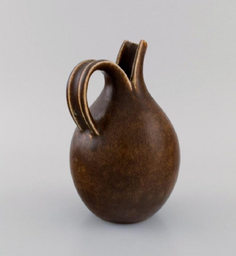 Eva Stæhr-Nielsen for Saxbo. Pitcher in glazed stoneware. 
Beautiful glaze in brown shades. Model number 64. 
Mid 20th century.
Measures: 19 x 13 cm.
Stamped.
In excellent condition.