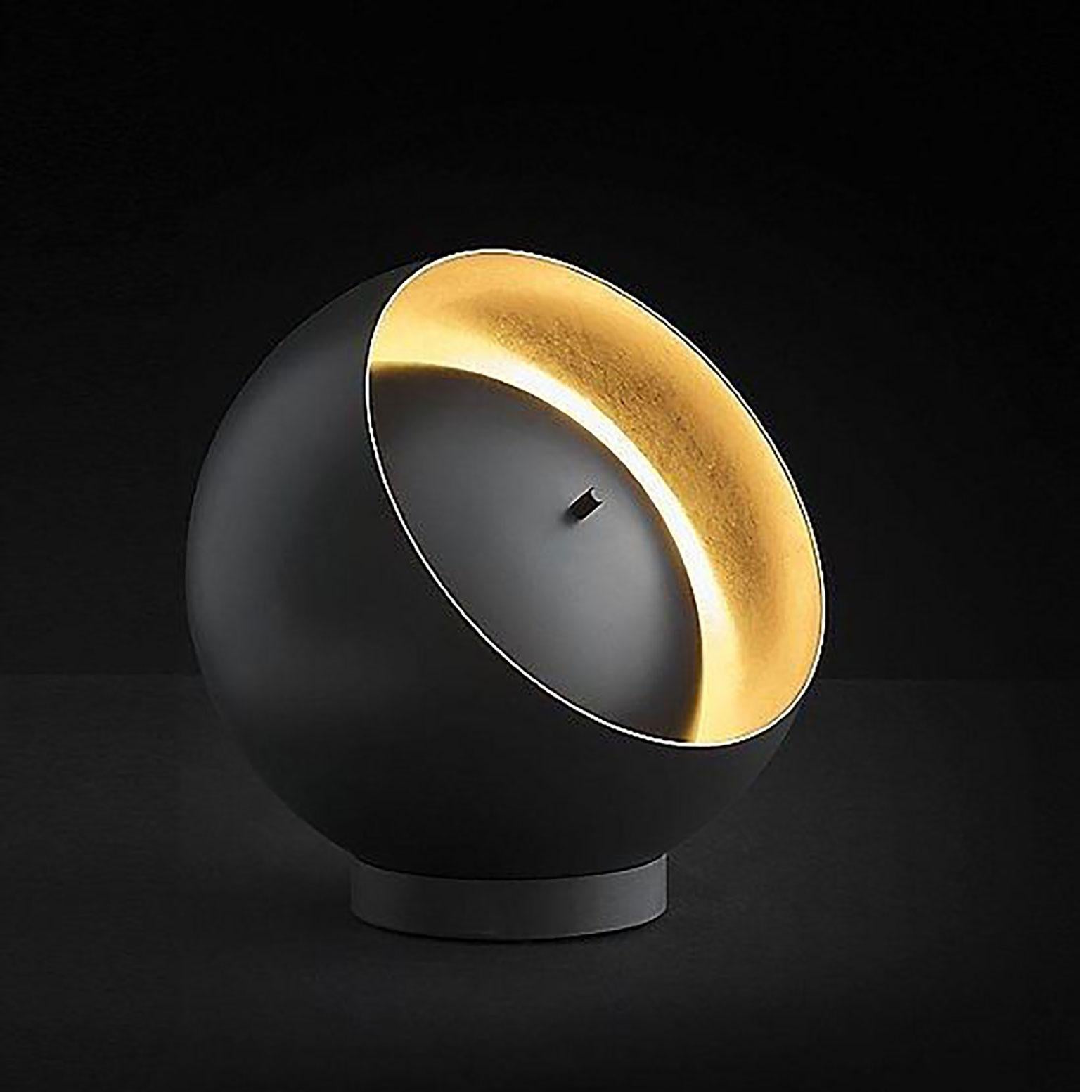 Eva table lamp designed by Francesca Borelli for Oluce. Francesca Borelli defined herself in the field of design. She has the ability for furniture and lighting design that is both passionate and conceptual. The black body of this lamp is a sphere