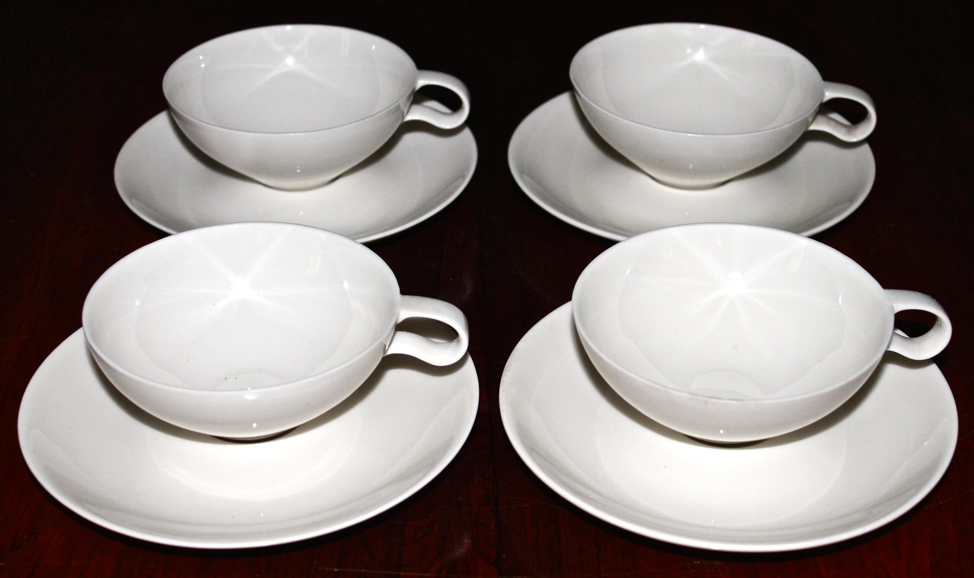 The original discontinued cups with the downward handles from the famous set commissioned by The Museum of Modern Art (MOMA). Four cups and four saucers, most are signed.