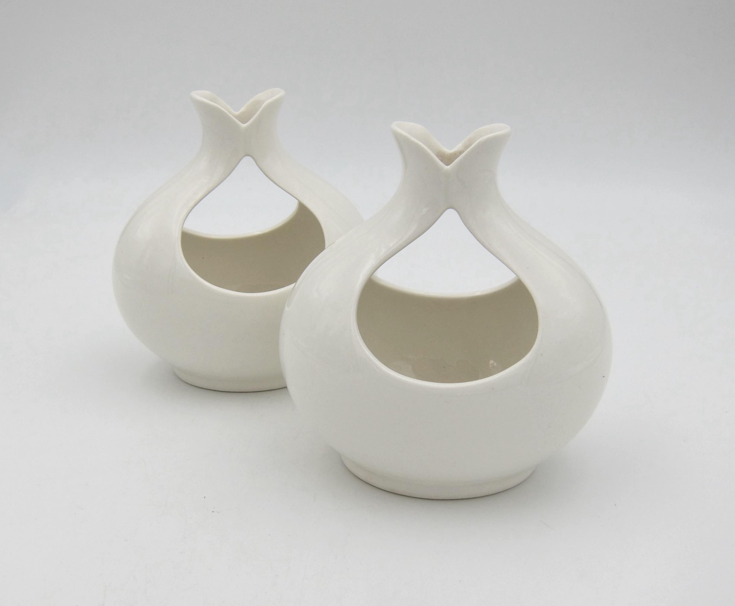 A pair of Tomorrow's Classic candle holders in white glazed earthenware designed by Eva Zeisel (1906-2011) between 1949 and 1950 for Hall China Company (Hallcraft) of East Liverpool, Ohio. The mid-century modern candle holders of oval form have