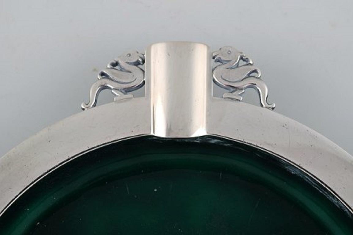 Evald Nielsen (1879-1958), Denmark. Art Deco cigar ashtray in sterling silver forged with duck motifs. Inside decorated with green enamel. Dated 1951.
Stamped.
In very good condition.
Measures: 20.5 cm.