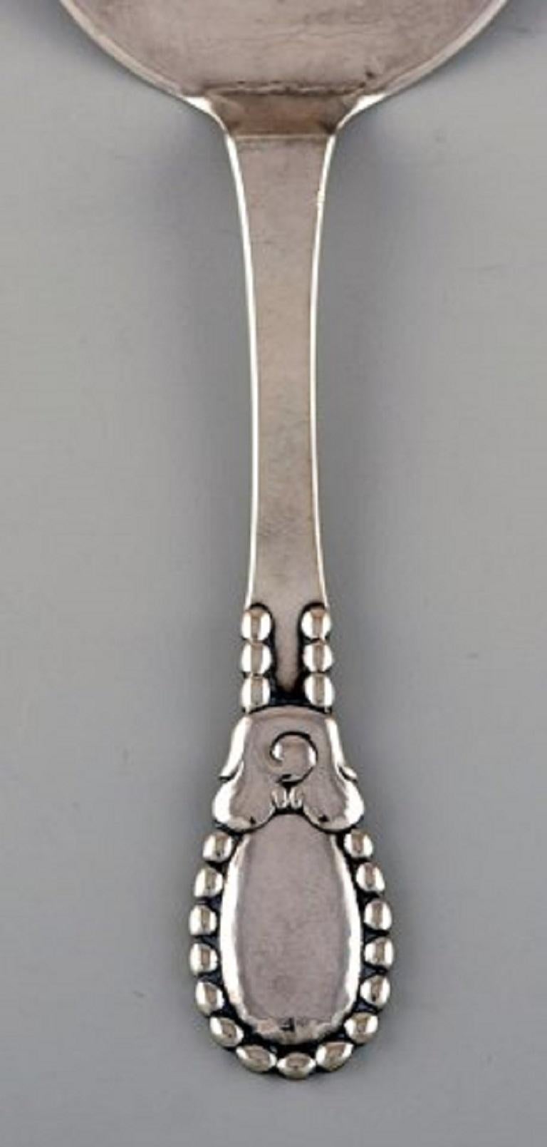 Evald Nielsen number 13 serving spade in hammered all silver 830. Dated 1922.
Length: 16.5 cm.
Stamped.
In excellent condition.
Our skilled Georg Jensen silversmith / jeweler can polish all silver and gold so that it looks like new. The price is