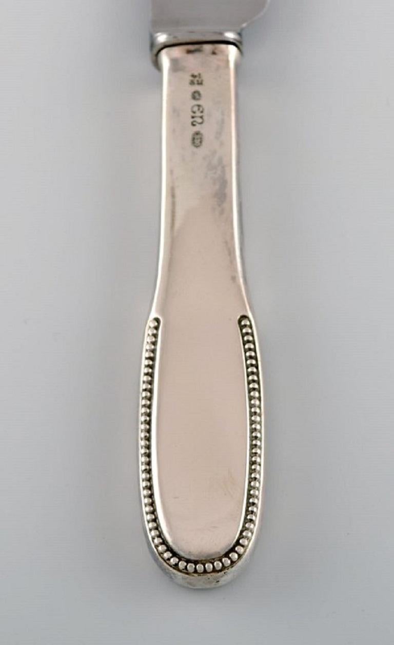 Evald Nielsen number 14 dinner knife in hammered silver 830 and stainless steel. 
1920s. 
Two knives are available.
Length: 23,5 cm.
Stamped.
In excellent condition.
Our skilled Georg Jensen silversmith / goldsmith can polish all silver and