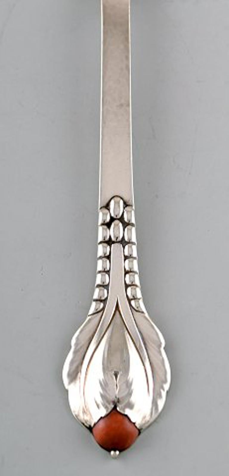 Evald Nielsen number 3, meat fork in hammered sterling silver with cabochon coral bead. 1920's.
Measures 23 cm.
Stamped.
In perfect condition..