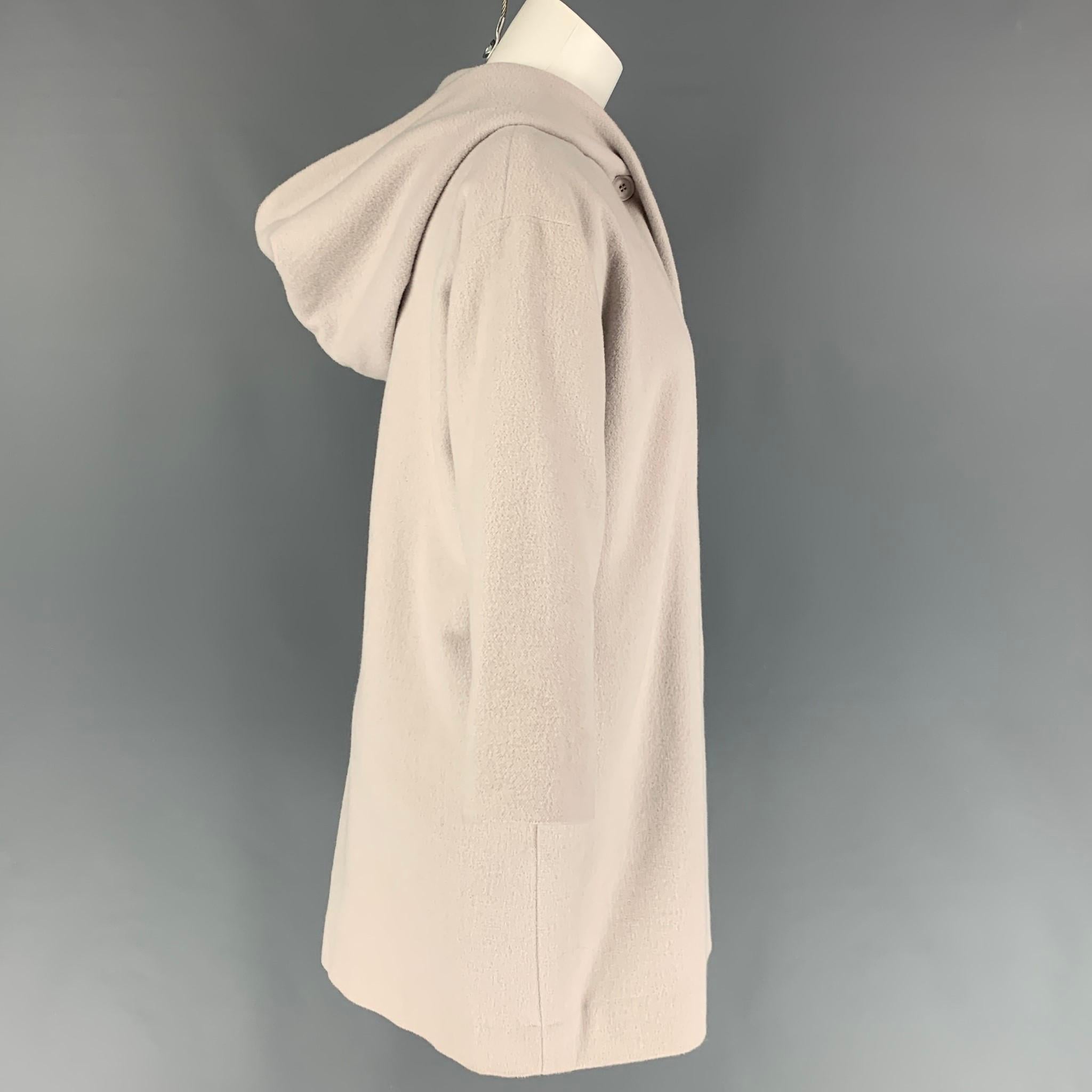 EVAM EVA coat comes in a dust pink wool / angora featuring a hooded detail, slit pockets, 3/4 sleeves, and a buttoned closure. Made in Japan. 

Very Good Pre-Owned Condition.
Marked: 1

Measurements:

Shoulder: 20 in.
Bust: 41 in.
Sleeve: 17