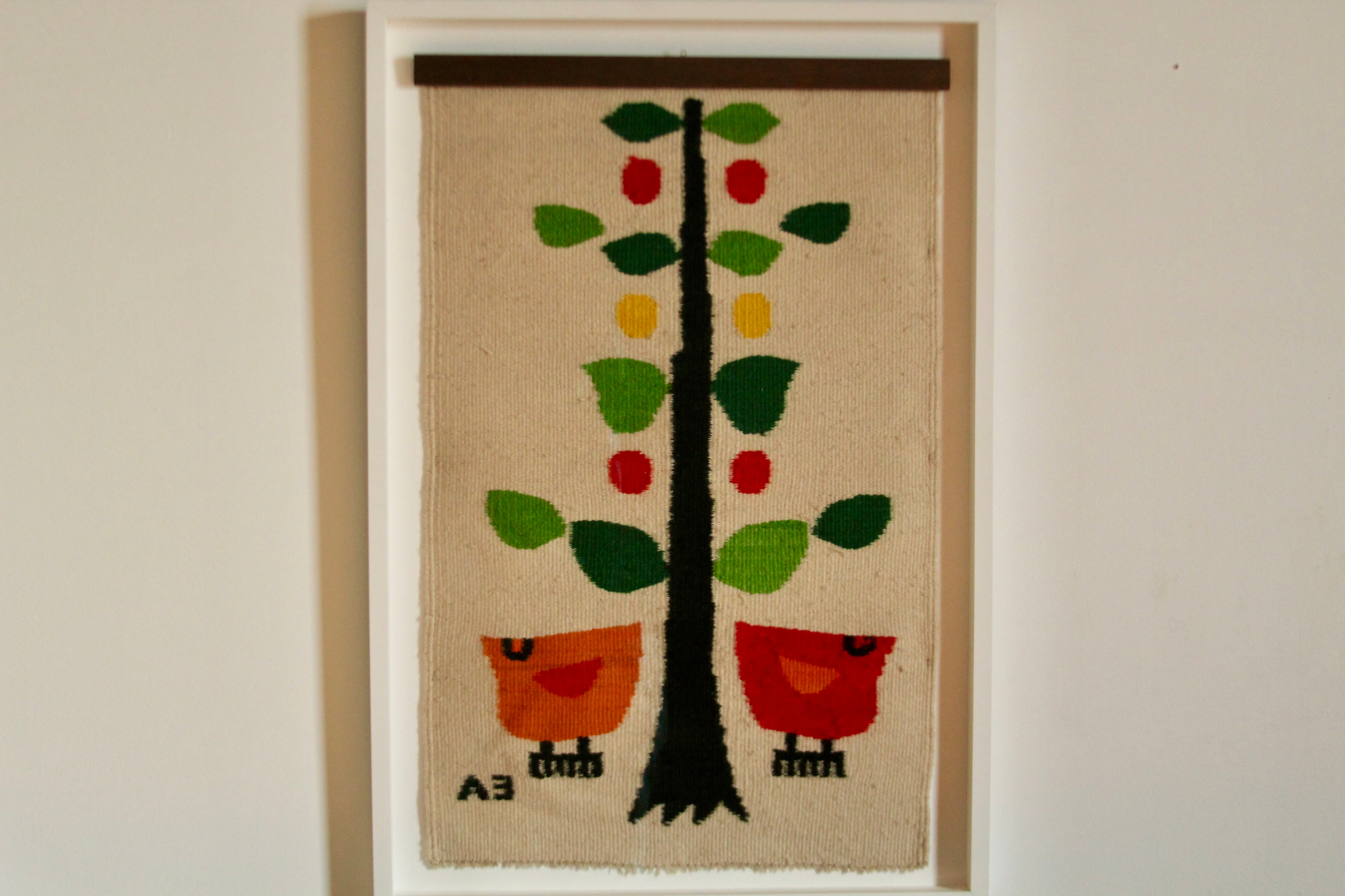 A wonderful, utterly charming woven wool tapestry by Evelyn Ackerman as part of the ERA line, depicting 2 birds and a tree in vibrant greens, red, orange, and yellow. This piece was hand woven in the 1960s by skilled weavers near Mexico City. This