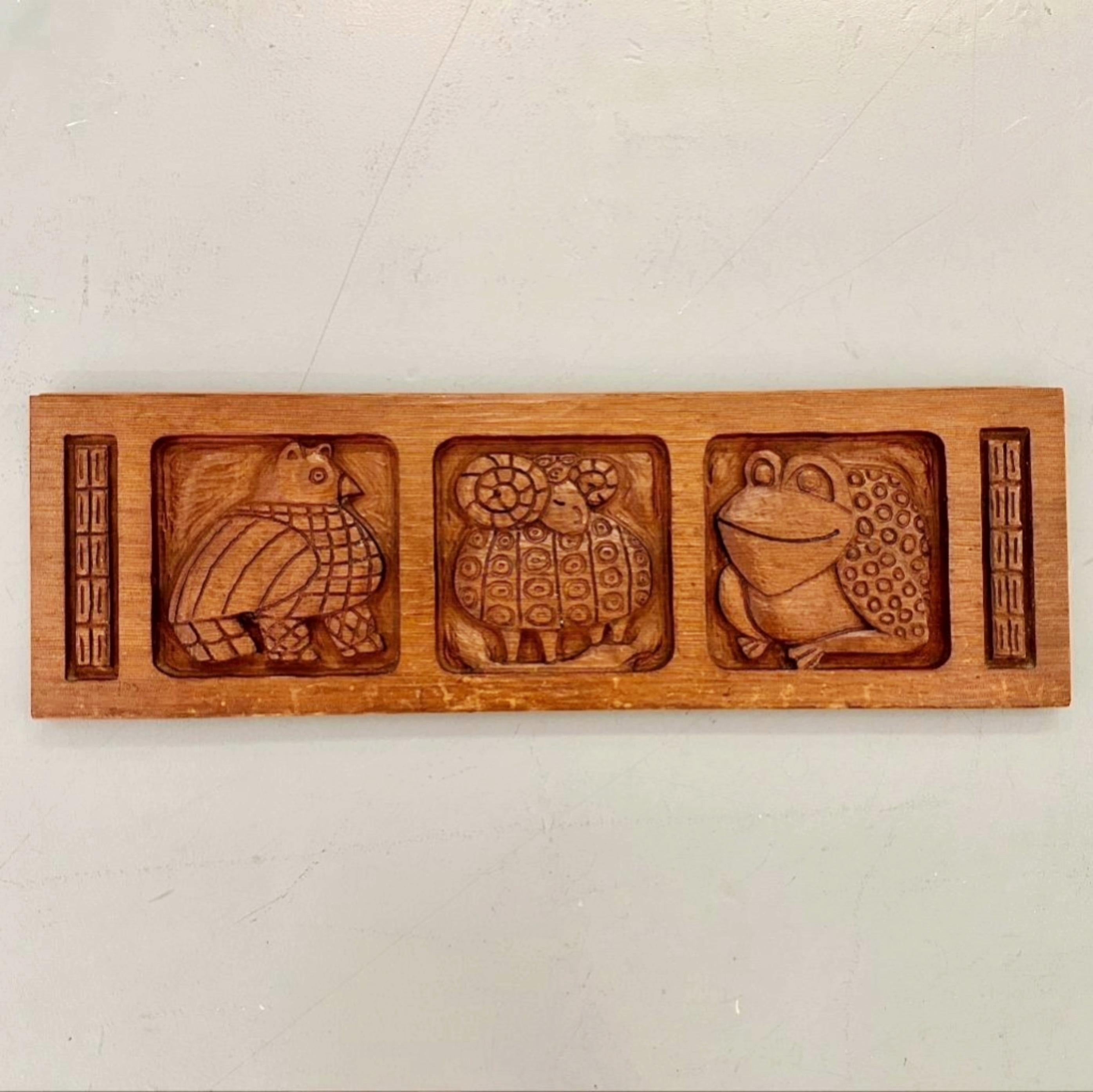 Panel de madera roja tallada de Evelyn Ackerman para Panelcarve, hacia la década de 1950. Presenta un pájaro, un carnero y una rana en el típico estilo Ackerman.

Mide 36