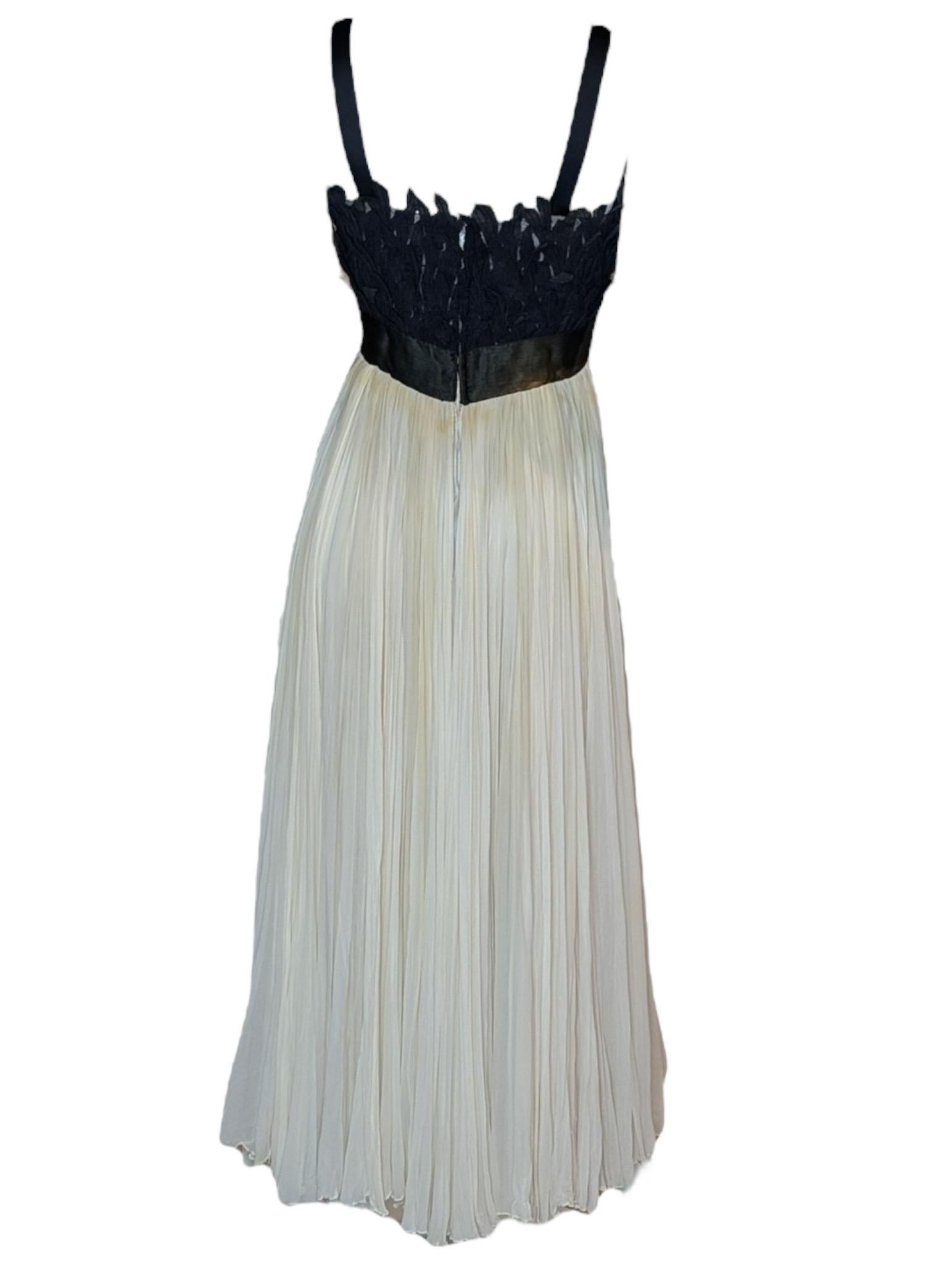 Une robe de soirée des années 1960 signée Evelyn Byrnes, qui illustre l'approche raffinée de l'époque en matière de tenue de soirée et de féminité sculpturale. Ce modèle de longueur de plancher présente un corsage ajusté en tissu noir foncé, orné de