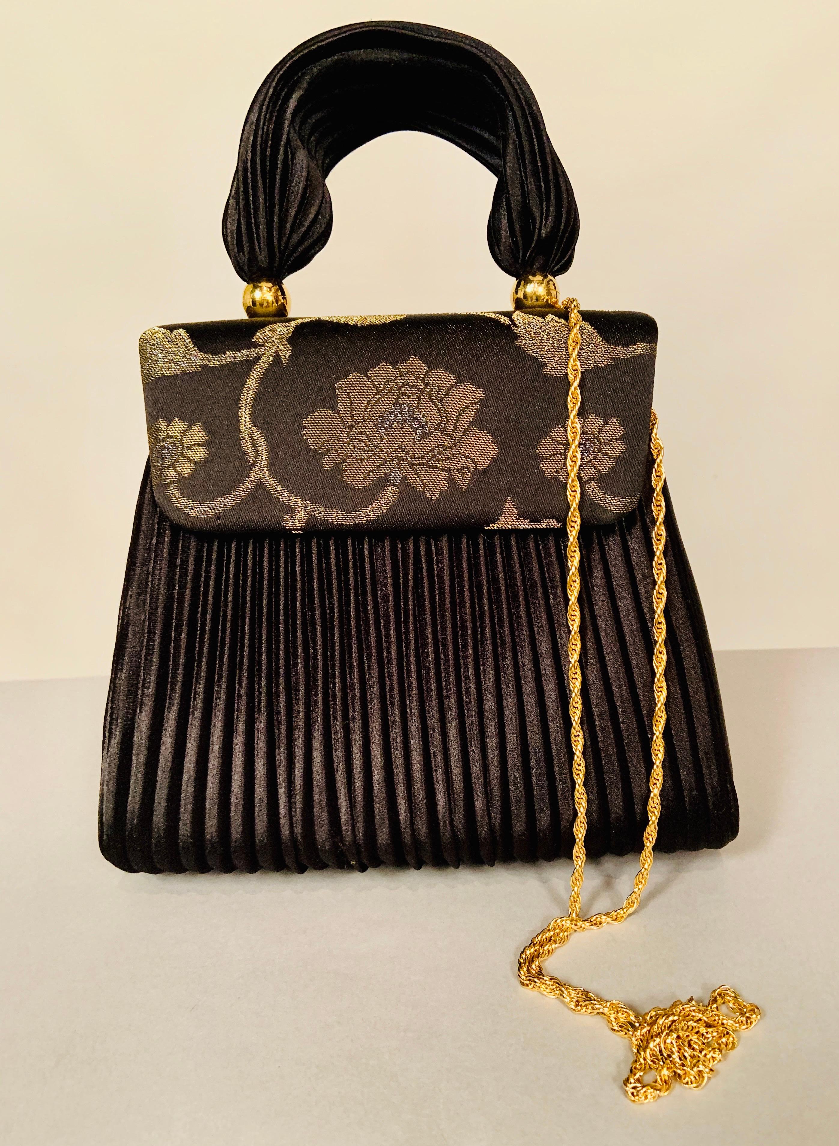 This elegant evening bag has more than enough style to compensate for the lack of a label. The handle and the bag are made form black Fortuny style pleated fabric and the top of the bag is silver and gold floral brocade. The interior is a pristine