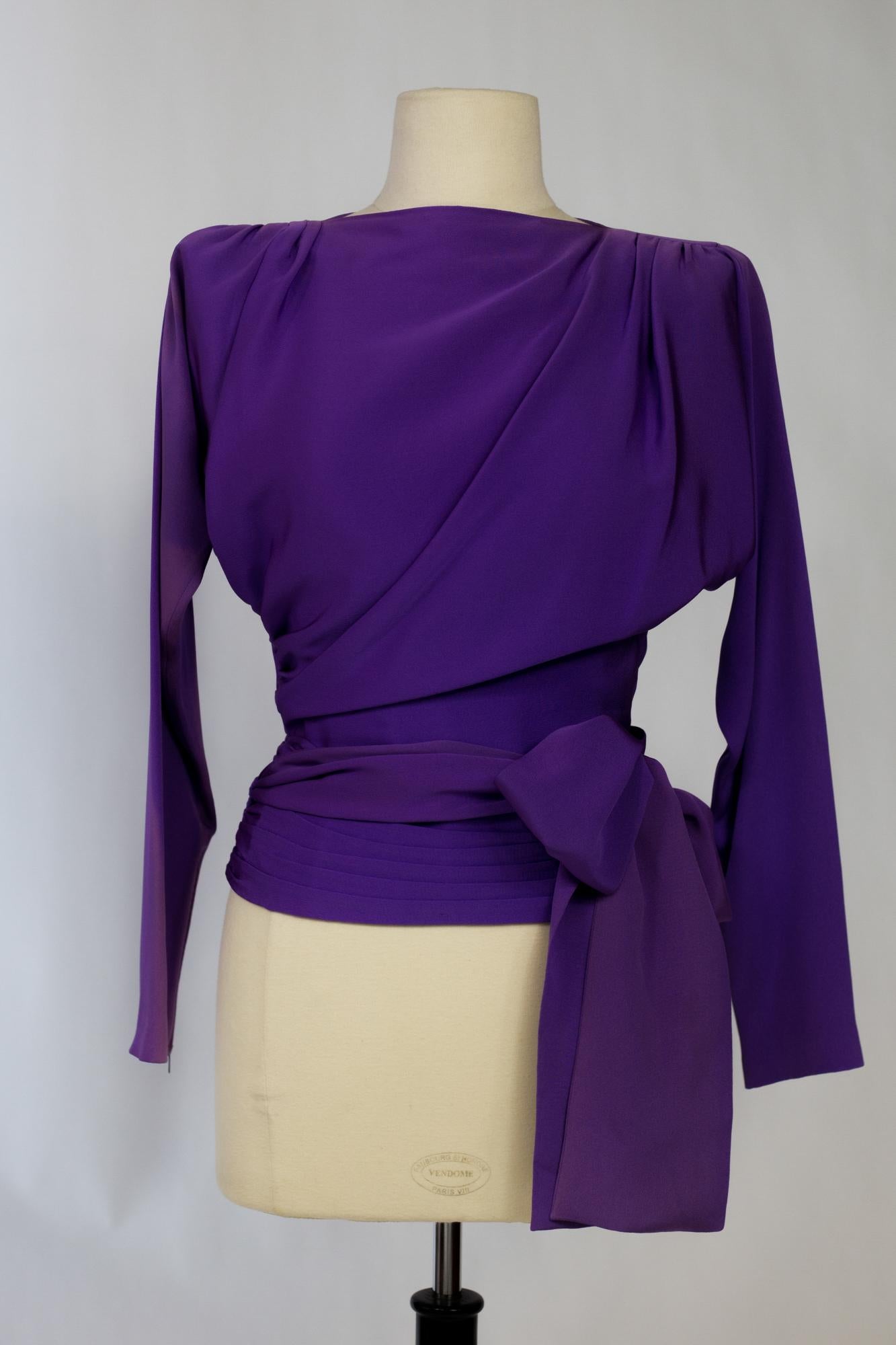 Circa 1990

France

Beautiful evening blouse in mauve silk Ottoman by Yves Saint Laurent Haute Couture. High waisted bustier with ragging long sleeves, shoulder pads and buttoned slit at the back neck. Elegant draping from the shoulders and wide