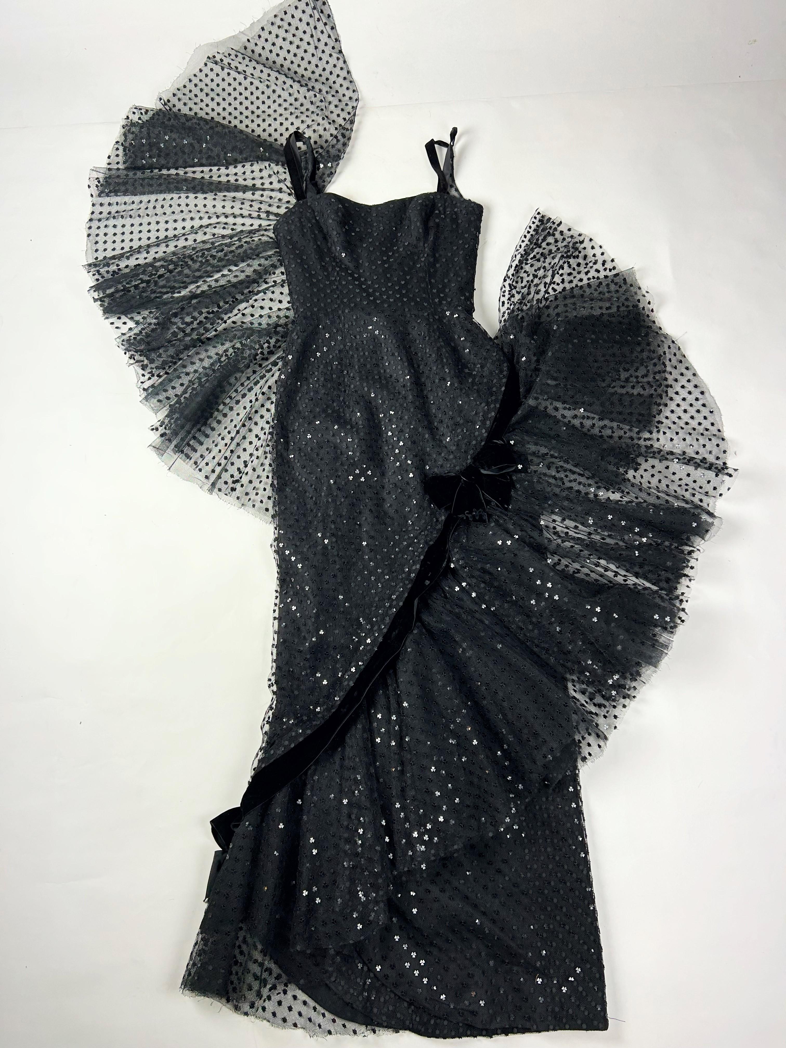 Circa 1958-1963

France

Spectacular black tulle evening gown embroidered with heart-shaped sequins by Jean Dessès Haute Couture and dating from the early 1960s. Sleeveless, tight-fitting and sheath-like dress emphasizing the silhouette. Large