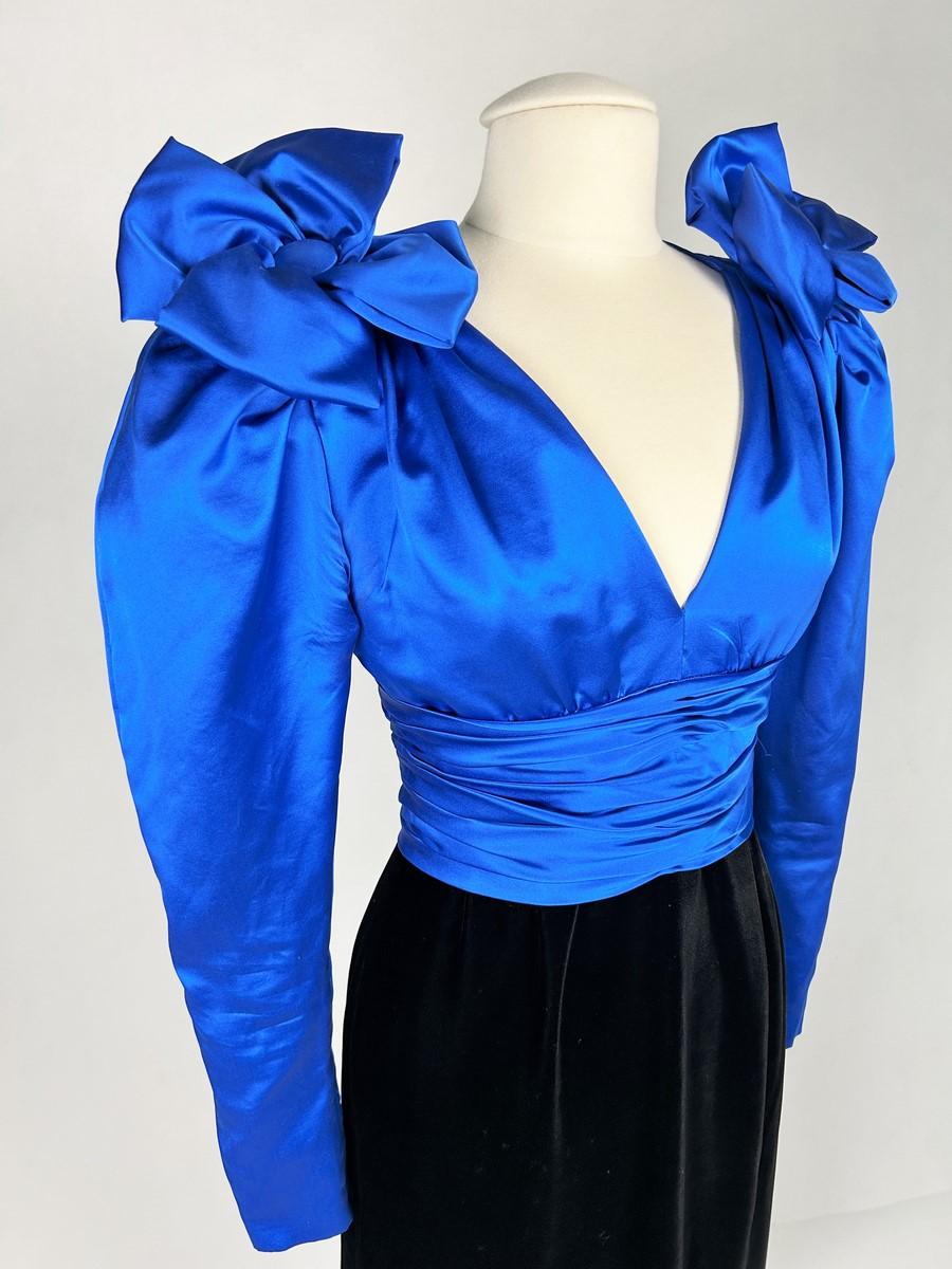 Circa 1987-1990
France
Elegant long evening dress in satin and velvet by the House of Nina Ricci directed by Gérard Pipart in the glamorous style of the late 1980s.  Strapless dress draped in electric blue or royal blue silk satin, with a V-neckline