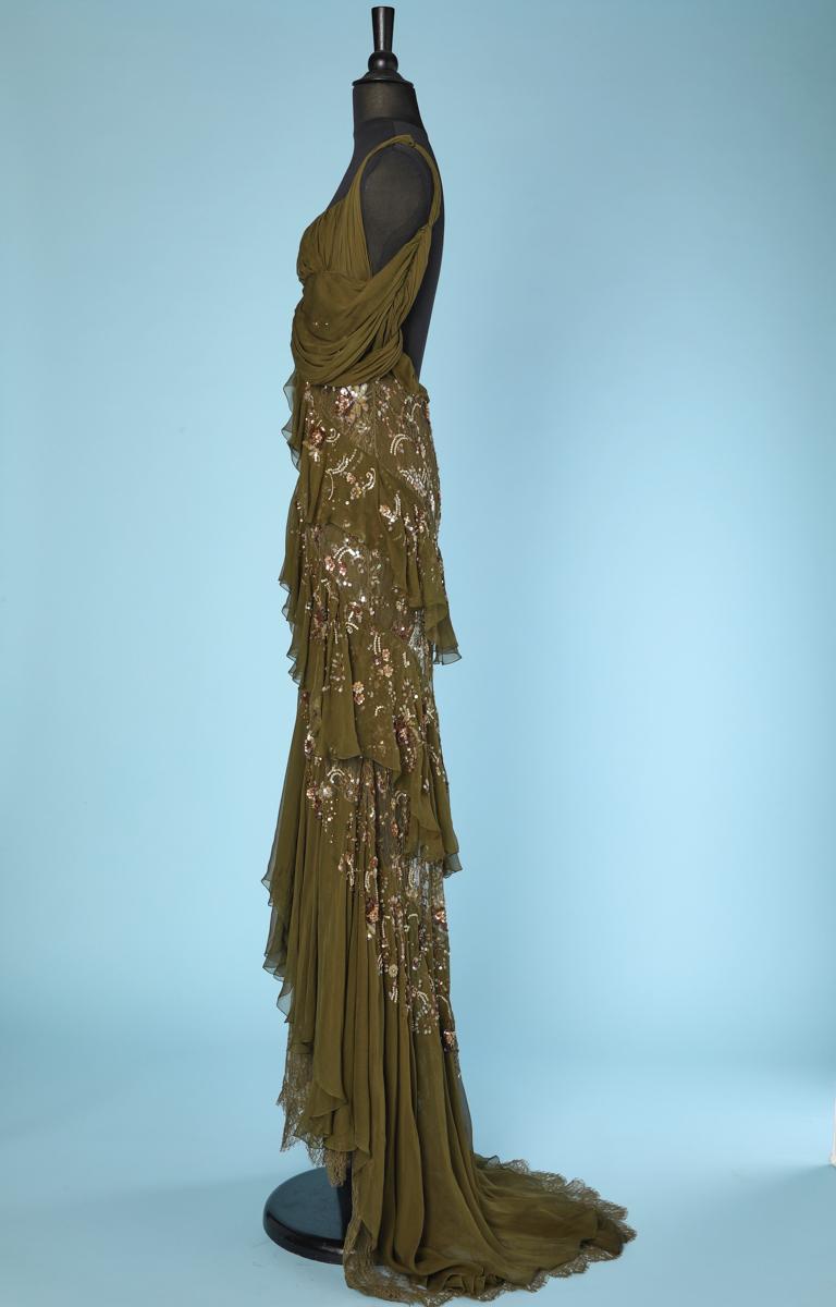 Evening gown in khaki chiffon pleated on the bust with lace flounces, embroidered with sequins and pearls, and a long train in the back, by John Galliano.
Size 36 french
model : 0077510