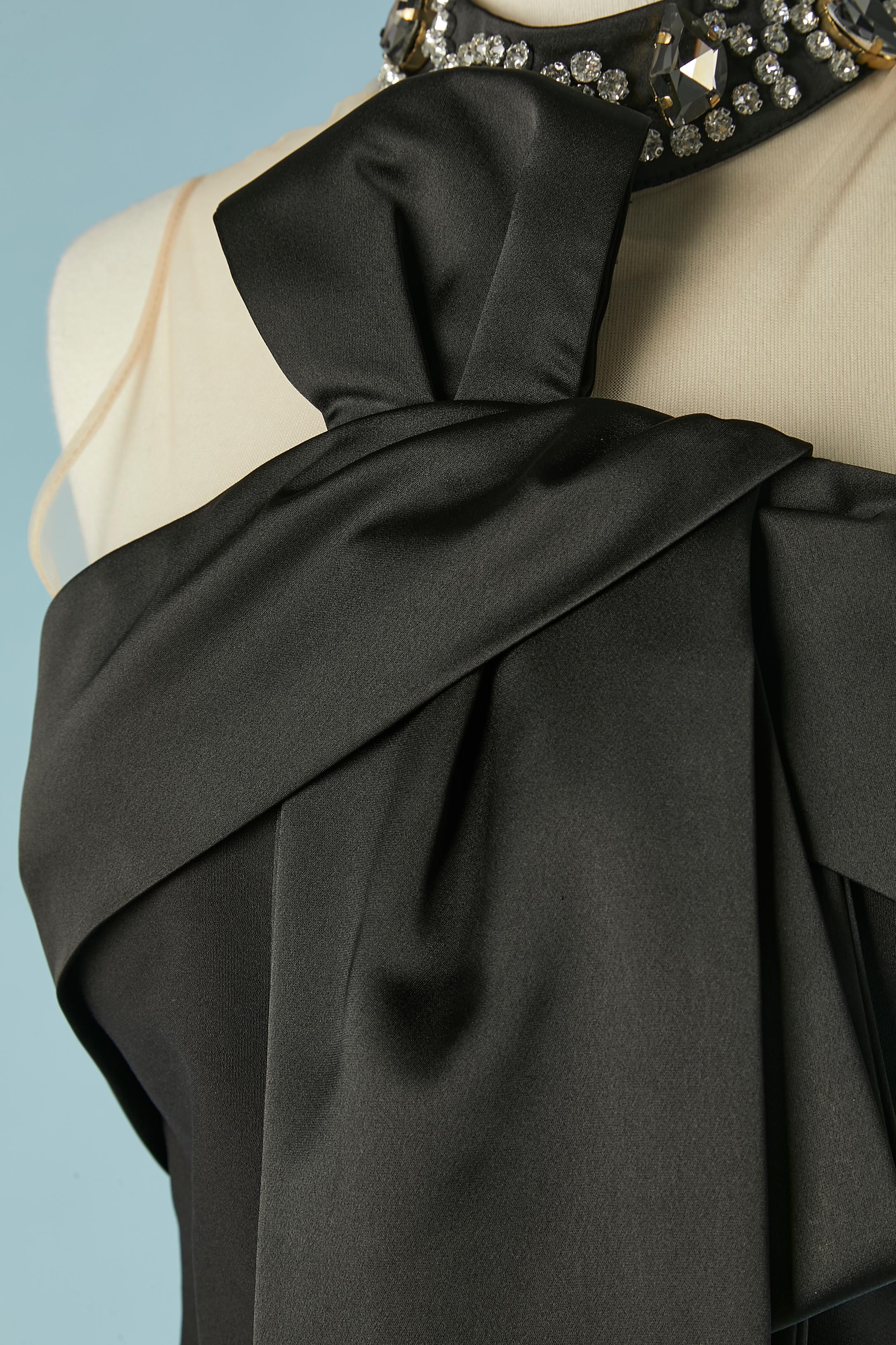 Black evening jumpsuit with satin bow and rhinestone neckless collar. No fabric composition tag but the main fabric is probably rayon & polyester and the bow and the bustier edge in satin. Button and buttonhole behind the neck and zip in the middle