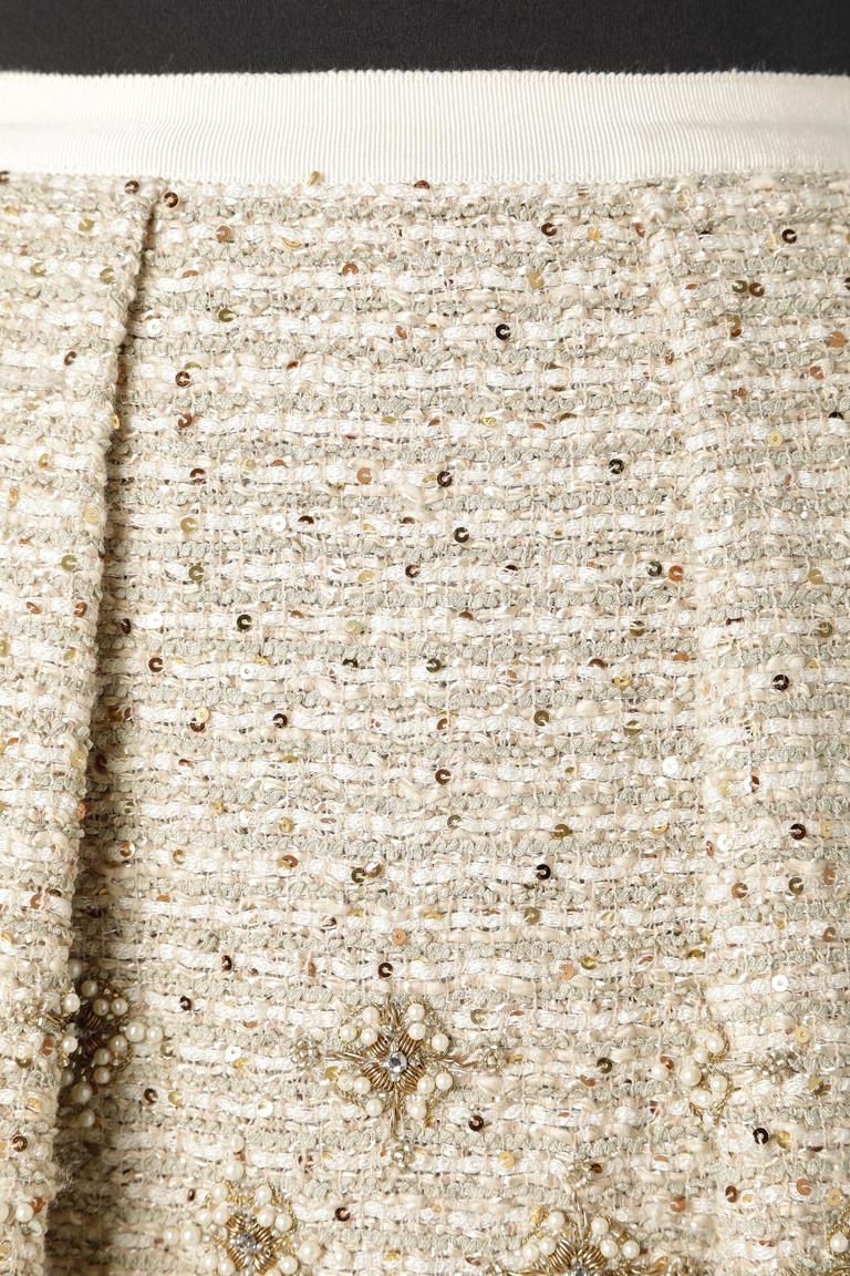 Evening skirt in embroidered tweed.Gros grain on the waist. Pockets. fringes edge in the bottom. Embroideries made of beads, rhinestone and gold lurex thread.Silk chiffon lining. 
SIZE 4 US