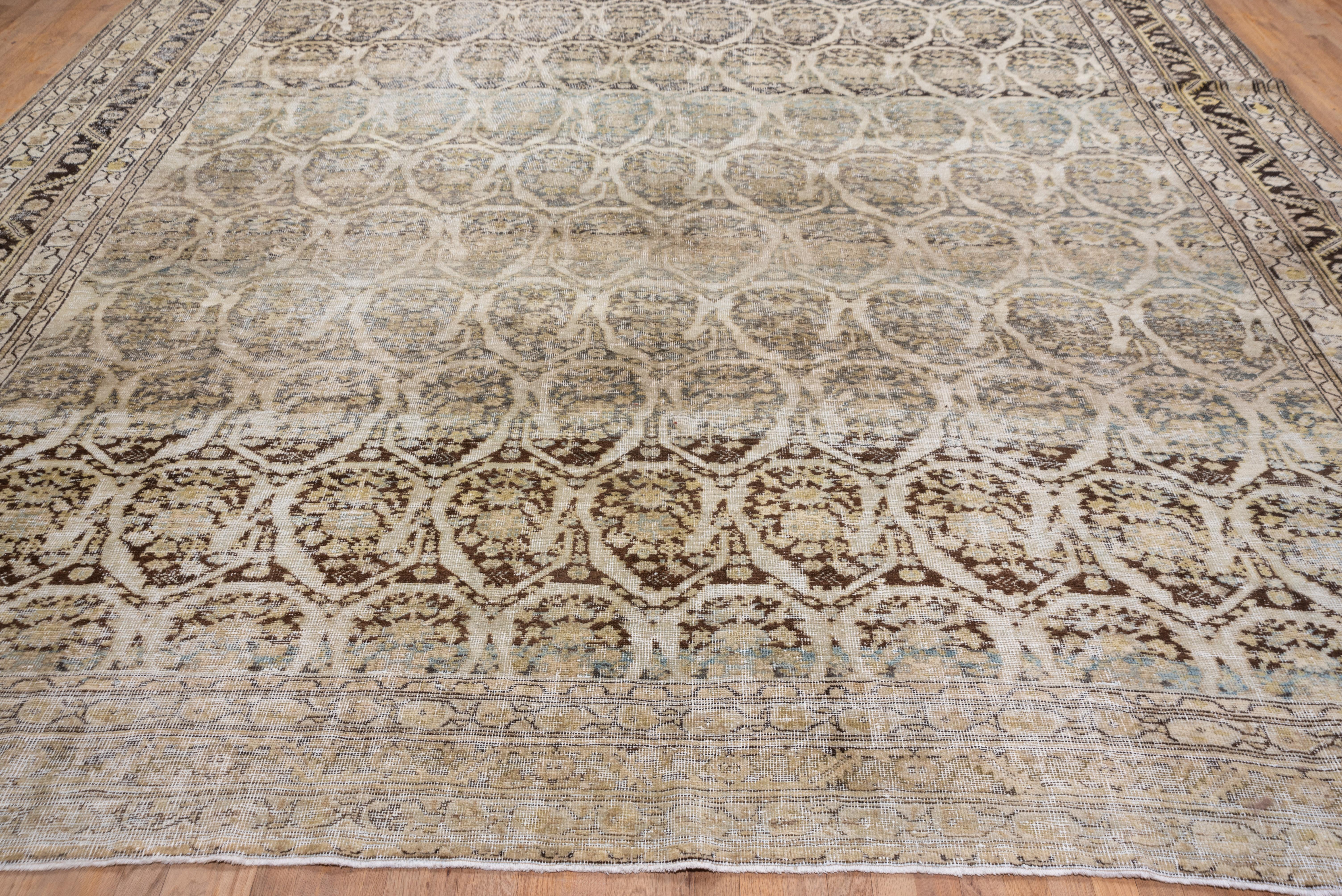This distressed mansion-size West Persian village carpet presents a dark brown field very closely covered with ecru-outlined botehs in reversing rows. Slate main border and straw-beige minor stripes.