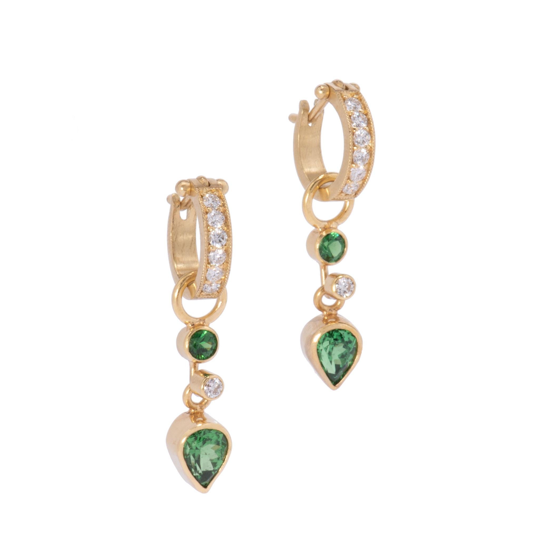 Deep pine green tsavorite garnets 2.29ctw, one round and one swinging teardrop sparkle with intensity above and below round white diamonds .10ctw and are hung on pave diamond hoops .36ctw. Both drops and hoops are hand crafted in our studio of 18k