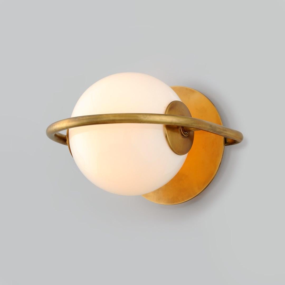 1-light wall sconce. Inspired by a pearl earring once belonging to Elizabeth Taylor, Everley exudes modern simplicity and a sense of luxury. Its asymmetry and alluring use of negative space charm in vintage brass. Everley is at once elegant and