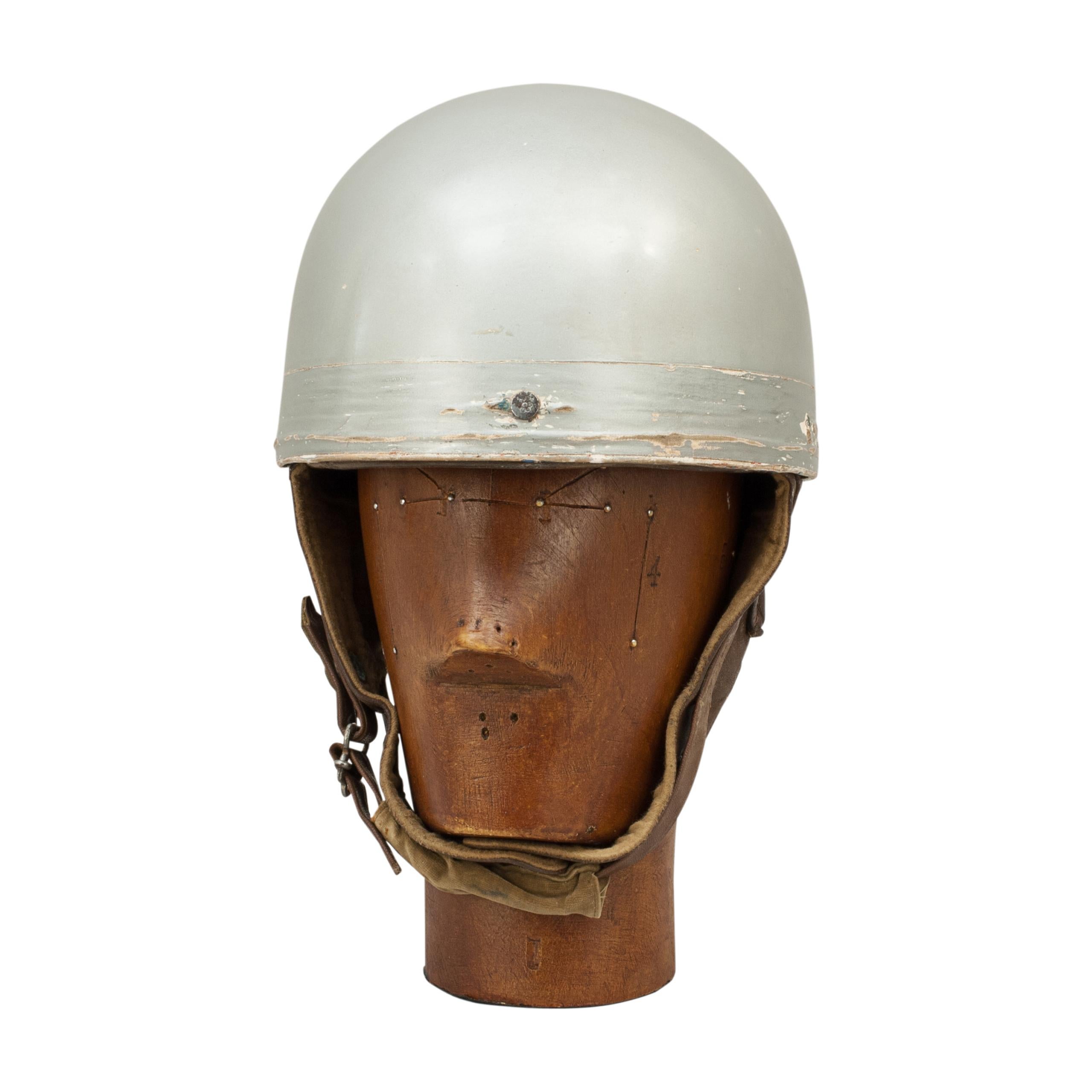 Vintage A.C.U. motorcycle racing crash helmet, Everoak.
A fine silver painted motorcycle helmet made in England by Everoak. This helmet has a cork interior, fitted with a leather headband and straps keeping a space between the head and outer case