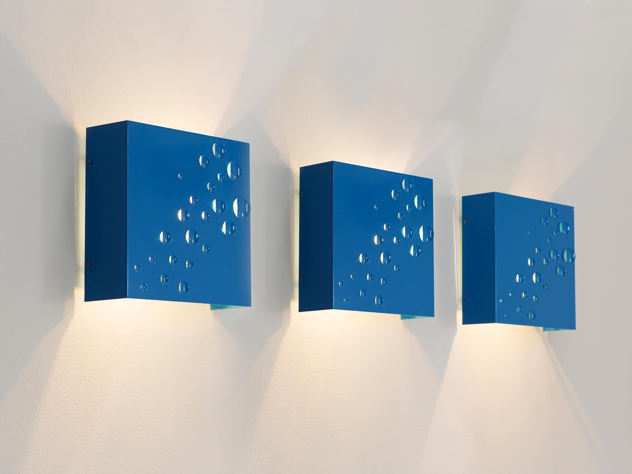 Evert Jelle Jelles for RAAK Amsterdam, Sterrenregen (Rain of Stars) wall lights, in painted steel, Netherlands, 1965. 

These blue wall lamps have a basic design which presents raised up round flaps which let the light shine through creating a star