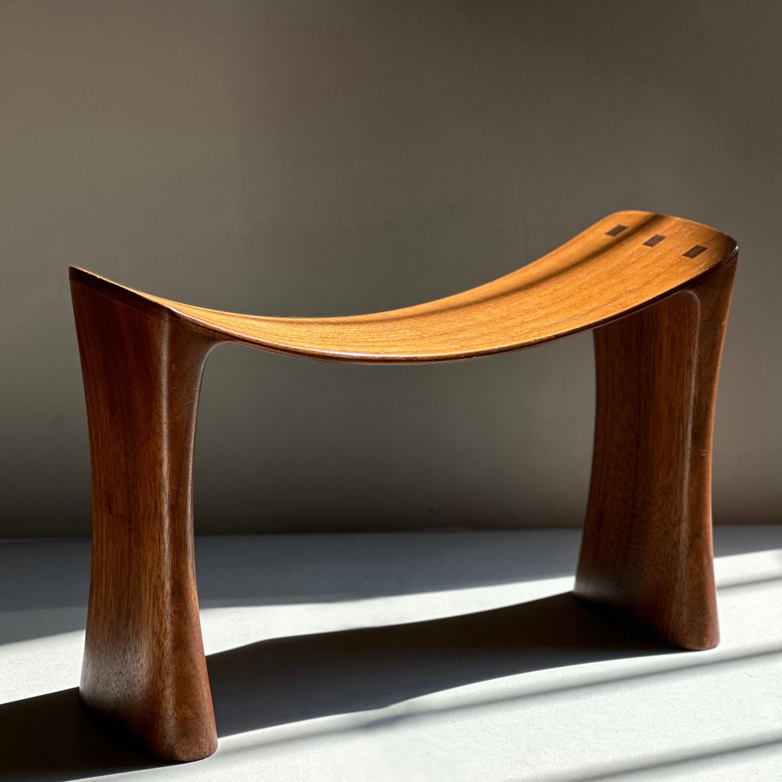 A sublime African tribal stool or headrest sculpture by Evert Sodergren, comprising gently carved legs supporting a bent lamination seat punctuated by visible joinery. This design was Sodergren’s response to a request from the artist Morris Graves