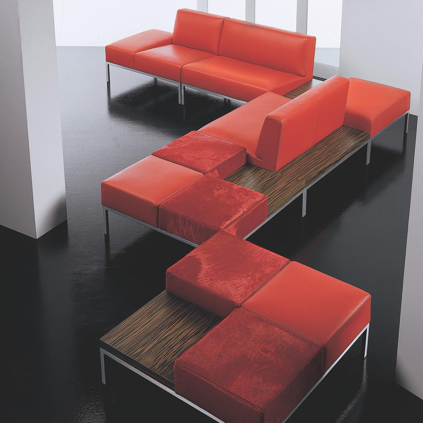 This modular pouf includes one integrated side table. The three seats of its chromed steel frame are covered in sophisticated, red pony hair with a lustrous sheen. The square side table measures 50x50 cm and features a veneered, zebra-striped