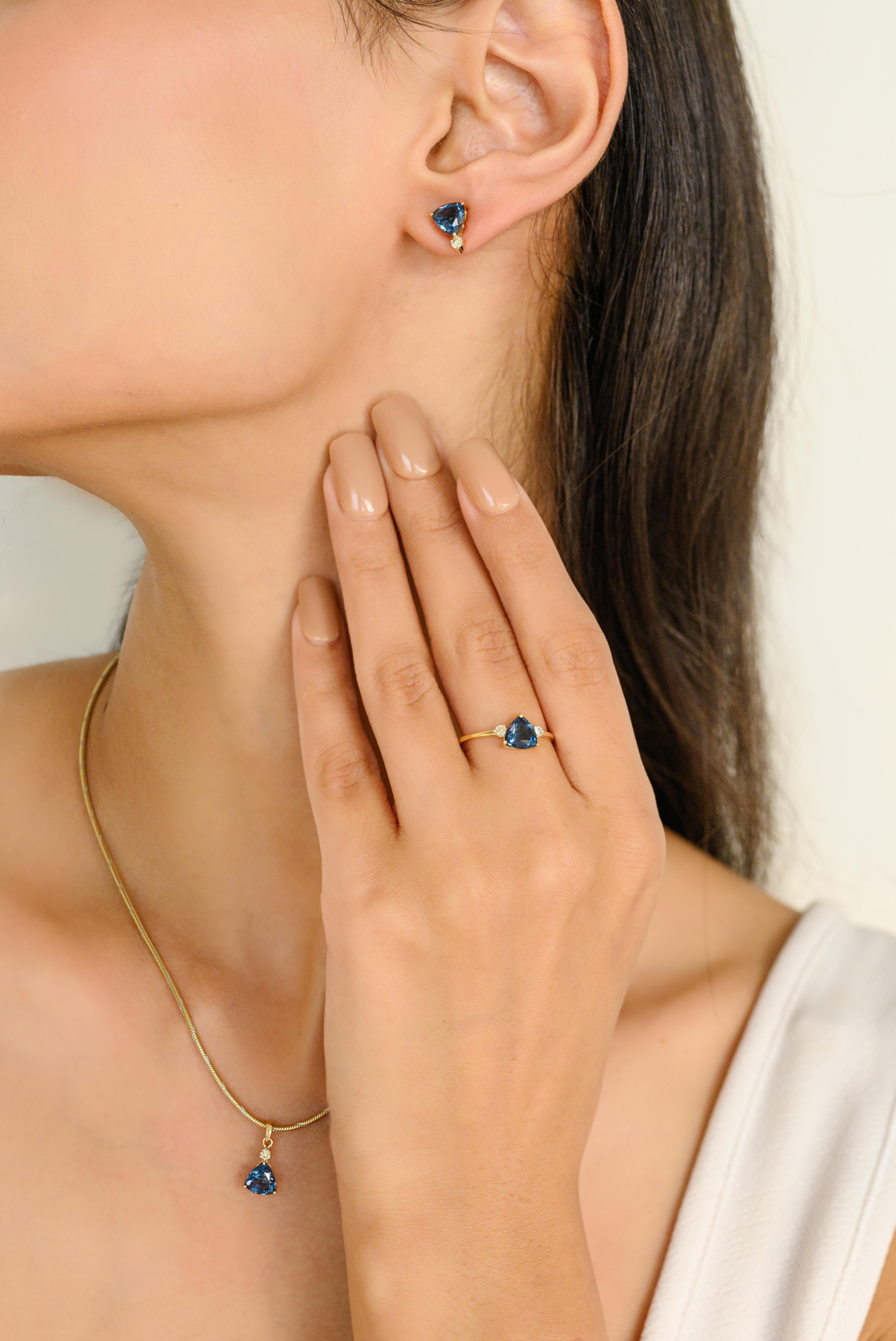 Boucles d'oreilles en or 18 carats avec topaze bleue de taille trillion et diamants ronds. Ce superbe bijou rehausse instantanément un look décontracté ou une tenue habillée. 
La topaze bleue favorise la vérité et le pardon et détend l'esprit et le