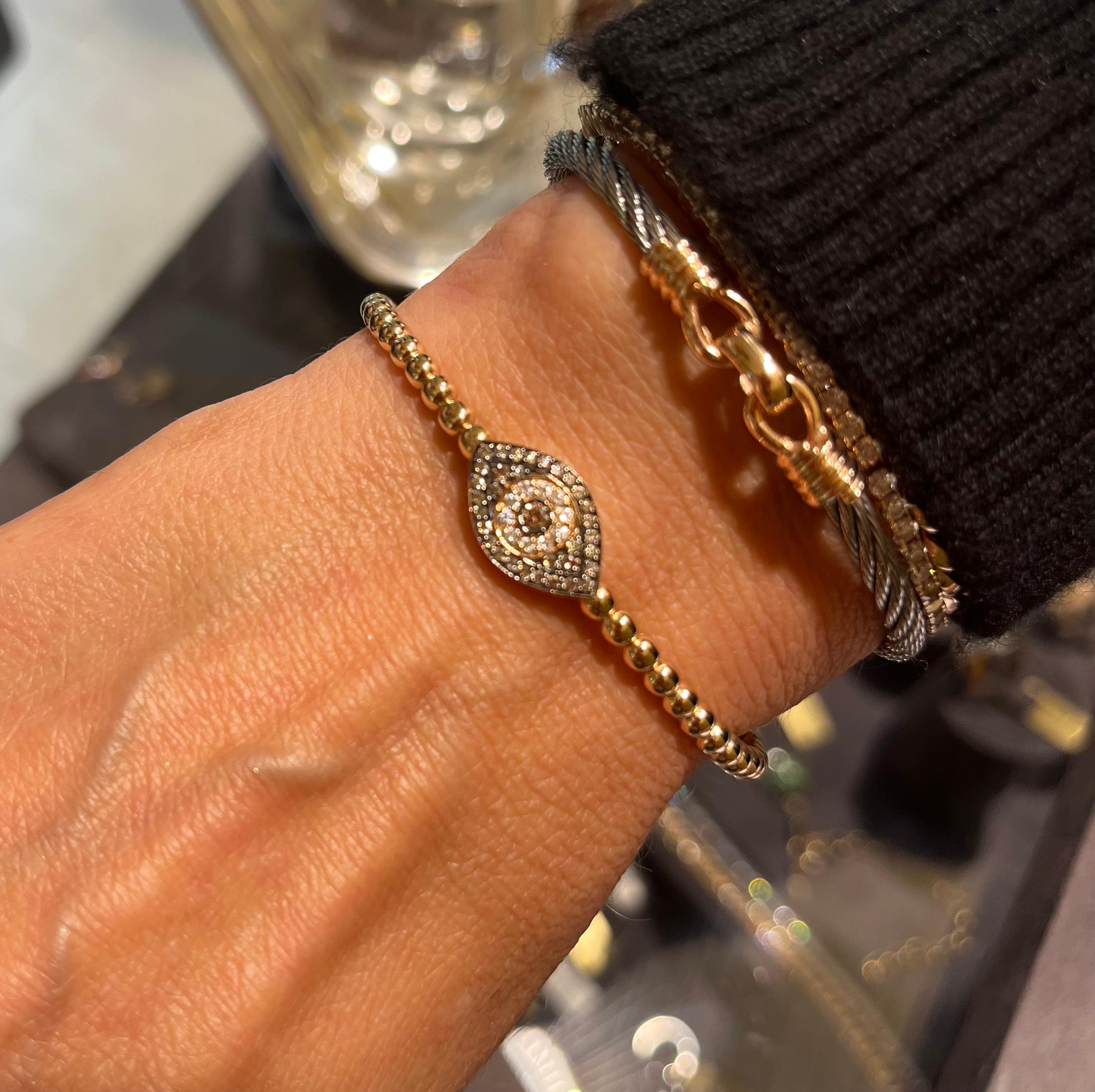 It is an 10,38 gr Gold bangle with diamonds
Evil Eye concept is one of the oldest concept coming from ancient traditions. It is  one of the strongest symbolic images in the world. Meri Lou elegantly redesigned the shape and made a modern, glamorous