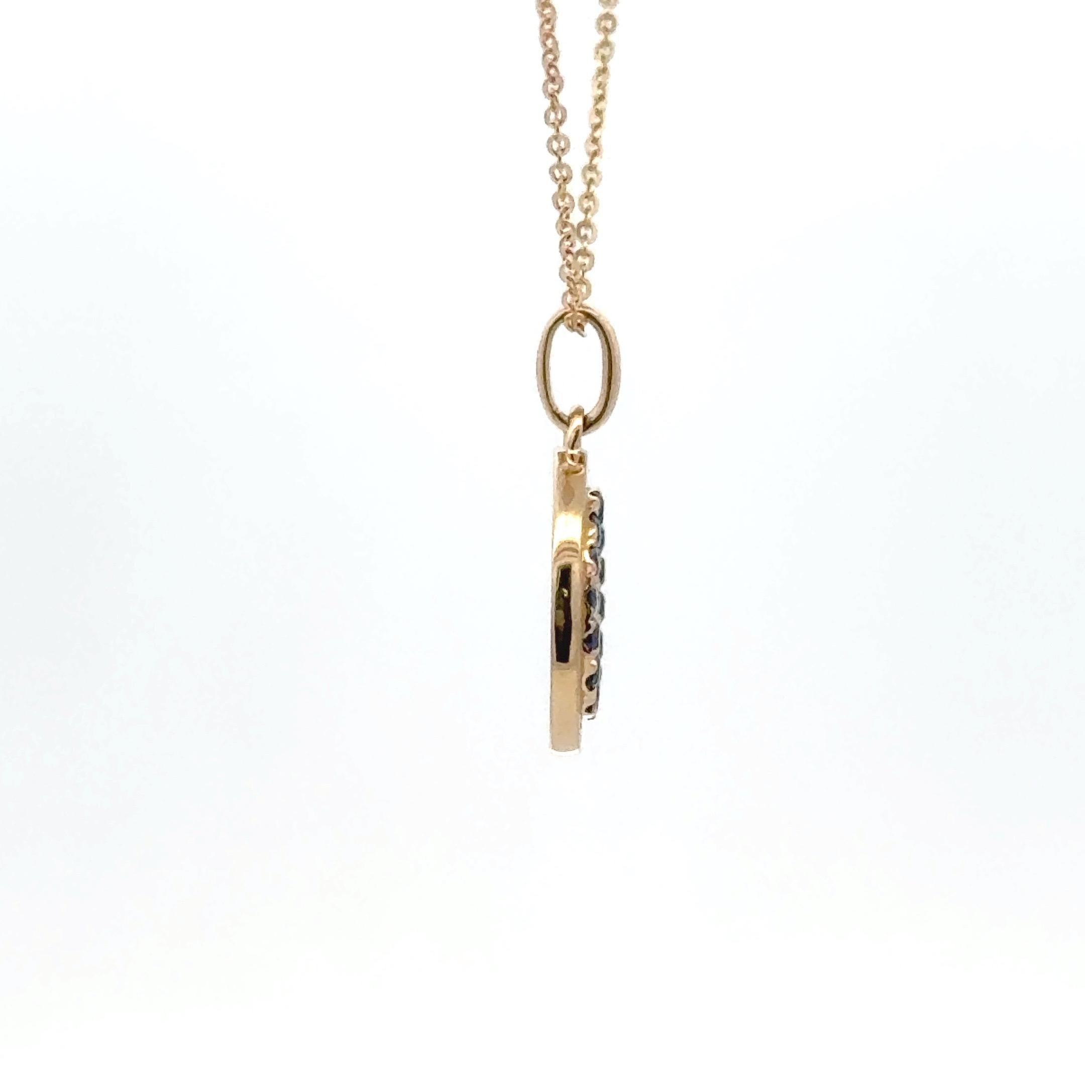 Élégant et symbolique, ce pendentif mauvais œil en or jaune 14k est serti de 8 diamants taille brillant totalisant environ 0,02 carats et de 17 saphirs bleus vifs totalisant environ 0,26 carats. Le design concentrique évoque le motif classique du