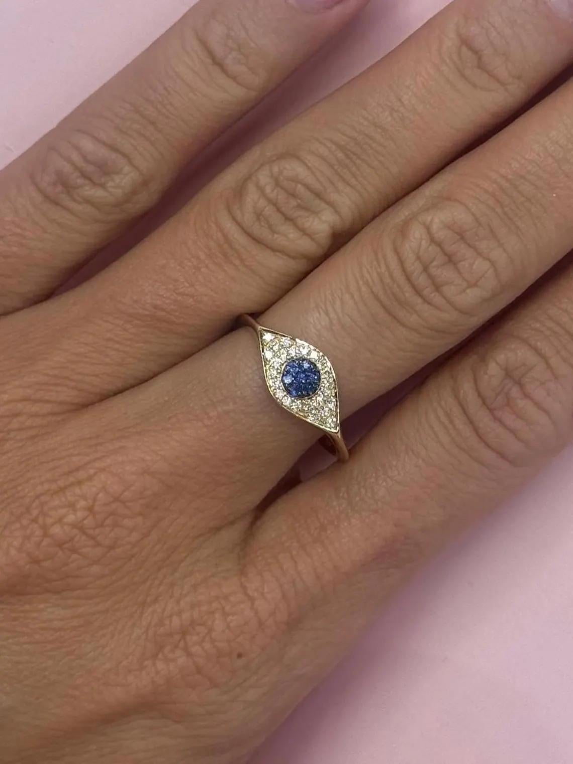 14 Karat yellow gold fashion ring featuring one Evil Eye motif containing round diamonds and a Sapphire design, weighing 1.65 grams. 
Sapphires - 0.10 Carats
Diamonds 0.15 Carats

More Evil Eye Jewelry in Stock.
Search Harbor Diamonds