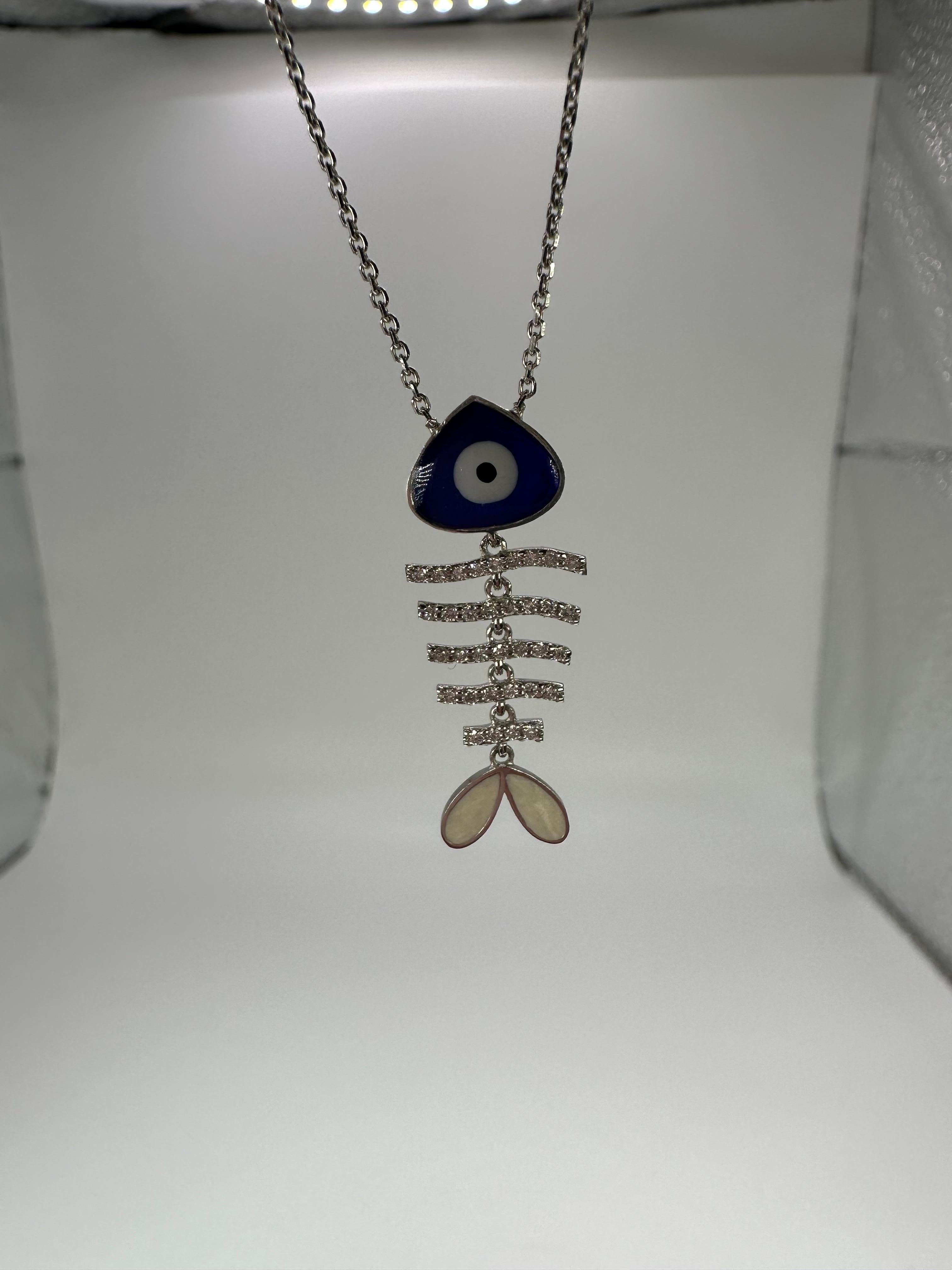 Modern fish bone pendant necklace with evil eye, sparkles like crazy made with gold, diamonds and fine glass and enamel. This piece is definitly one of a kind!

GOLD: 18KT gold
NATURAL DIAMOND(S)
Clarity/Color: VS/G
Carat:0.17ct
Grams:3.40
Item#: