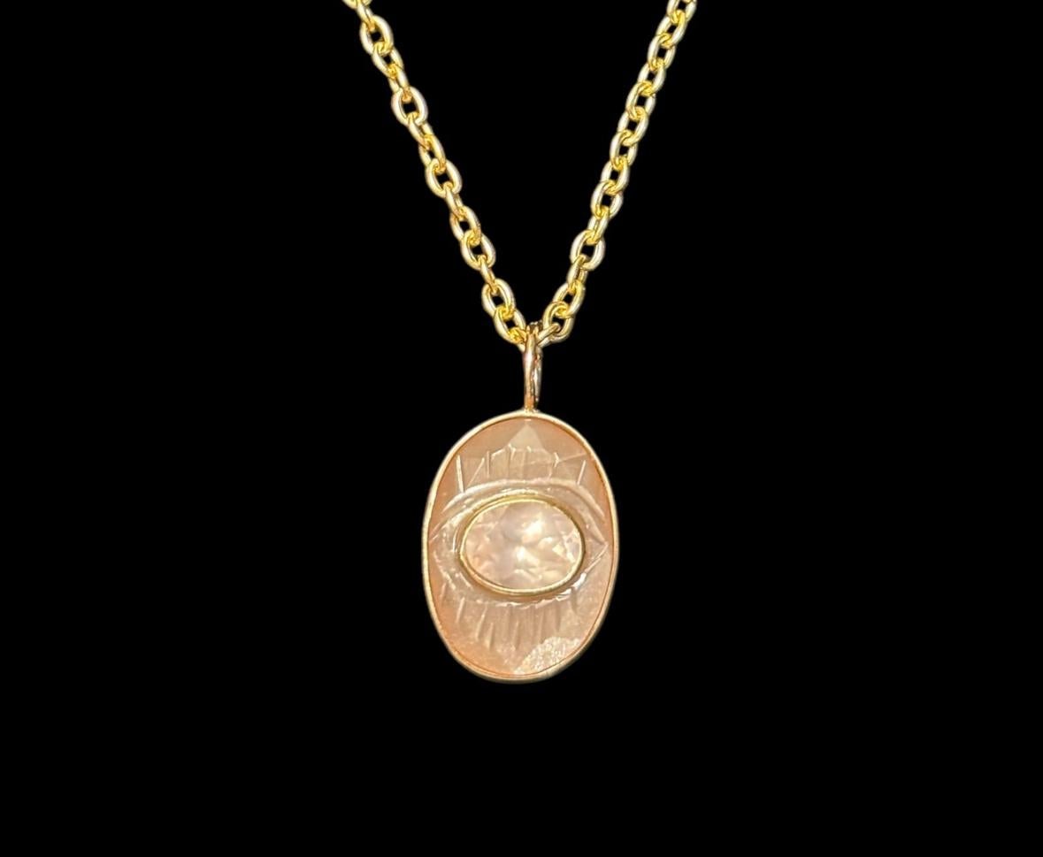 Ciondolo a forma di occhio maligno

Malocchio scolpito in pietra di luna color pesca con castone in oro 14k e quarzo rosa ovale centrale di 8x6 mm, anch'esso con castone in oro 14k. 

Il ciondolo misura 20x15 mm, esclusa la cauzione. 

Si tratta di