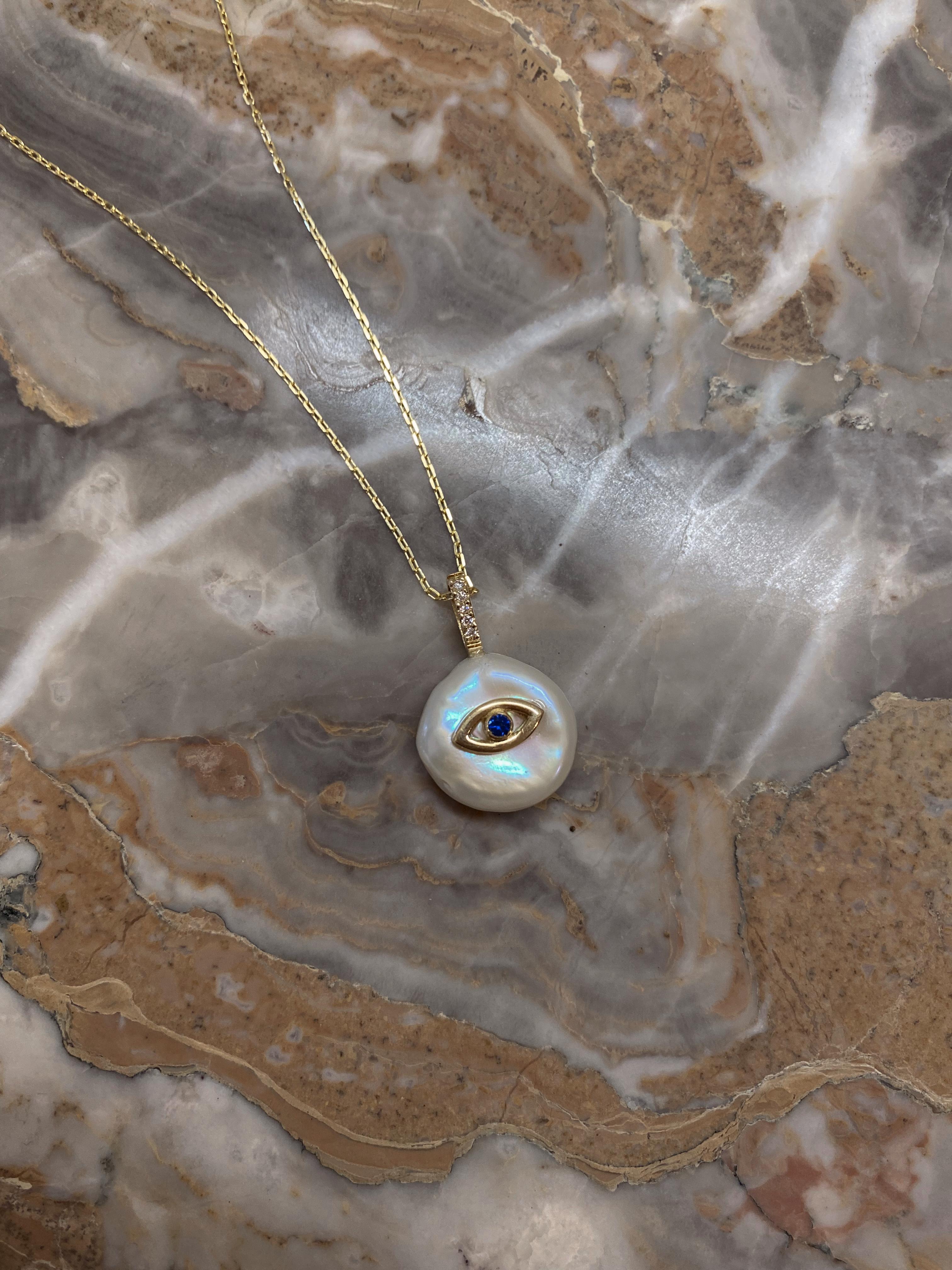 Our ‘Evil Eye Petal Necklace’, is casted from 18Karat Yellow Gold and set with natural sapphire and natural glimmering diamonds on a freshwater petal shaped pearl. It is designed to protect its wearer and ward off any negative energy. 
Each petal