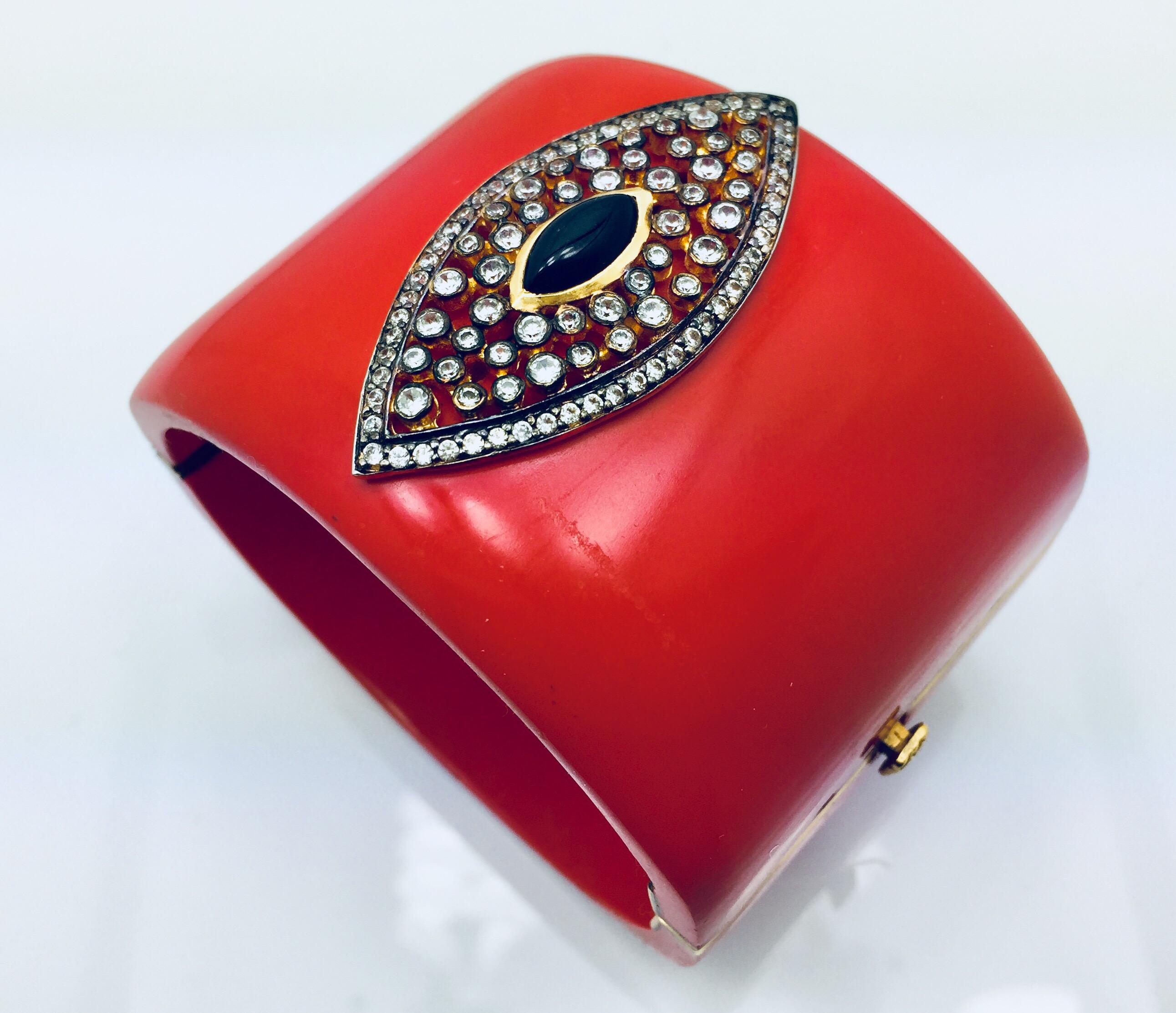 The red marquise cuff is a cuff even wonder woman would be envious of. The bold piece includes a marquise cut black onyx stone surrounded by a cubic zircon. The bracelet is hinged and fastens with a push tab insert closure.   As featured in Vogue