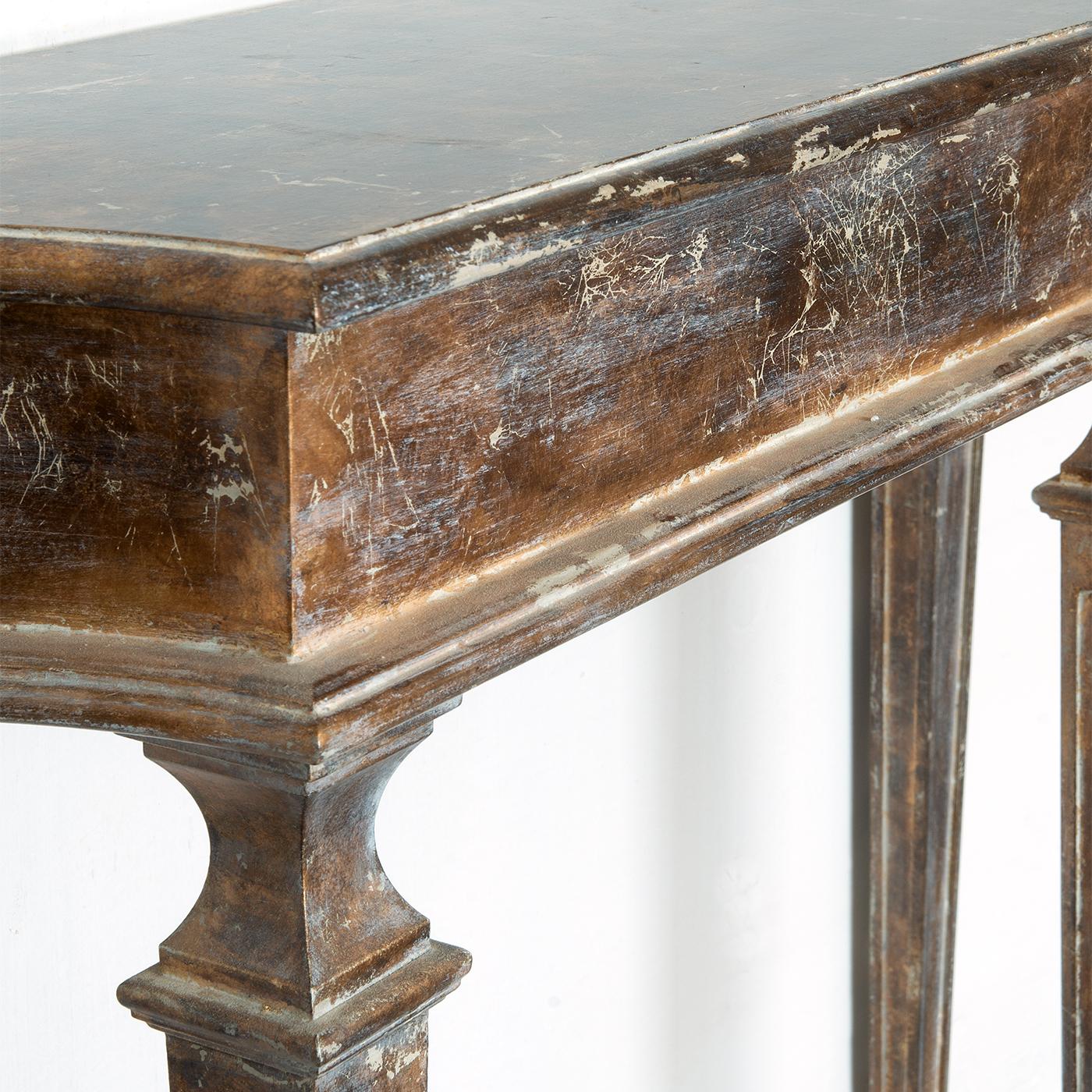 La console en bois Evins est une pièce de transition. Il s'inspire du style néoclassique mais réinterprété de manière nouvelle et contemporaine. La finition est unique : feuille de métal doré oxydée. Il est parfait pour un salon, mais il convient à