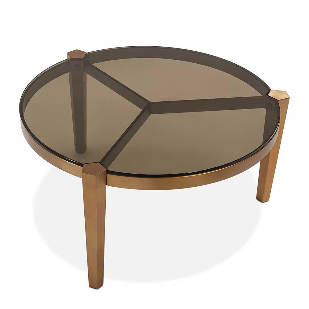 Table basse Evoca avec structure en acier en
finition bronzage et plateau en verre smocké.
