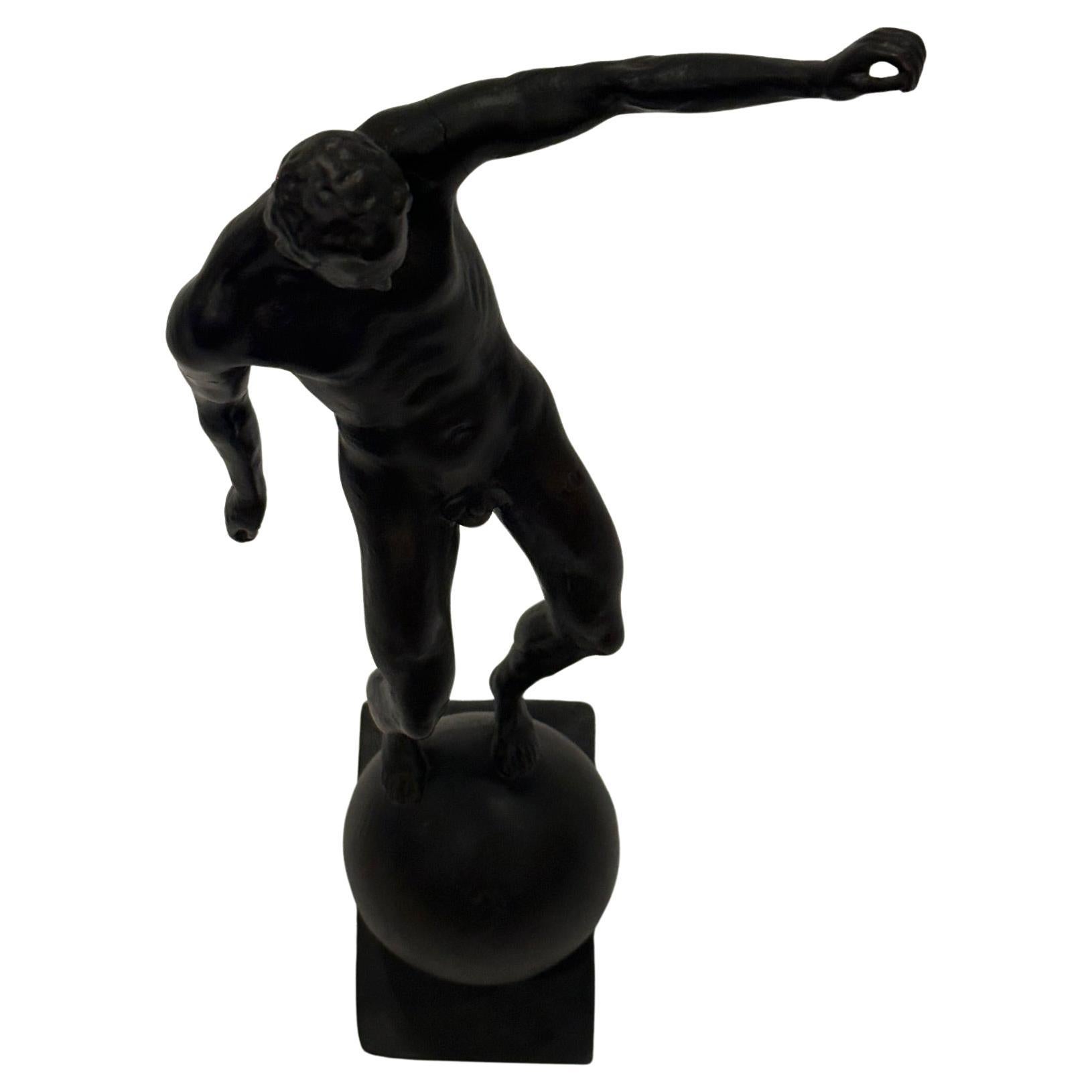 Striking classical bronze sculpture of a male nude standing on a ball having incredible attention to detail and marvelous gesture.