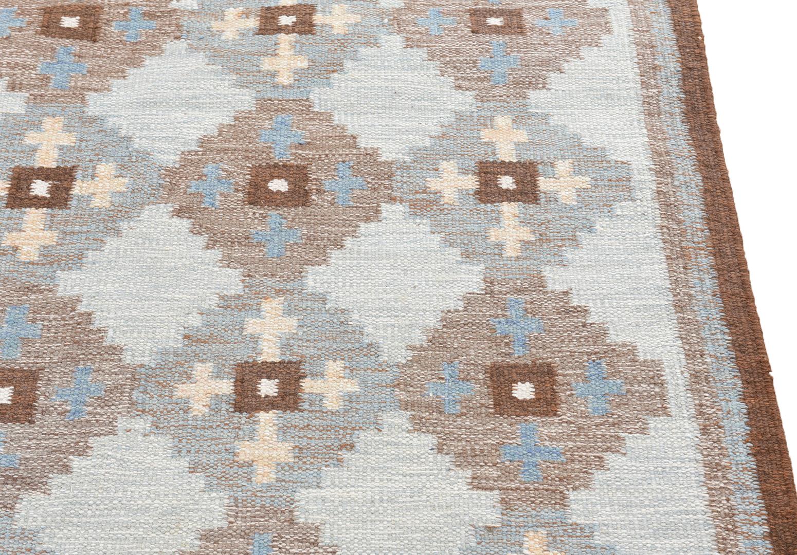 Mid-century Swedish rug-carpet, hand woven wool, flatweave ‘röllakan’ by Evy Svensson. Geometric pattern in white, (light)blue and brown, 200 x 142 cm. Signed “ES”. 
Designed 1950s. 
Measures: W: 200 cm, D: 142 cm.
Hand woven wool. Kilim