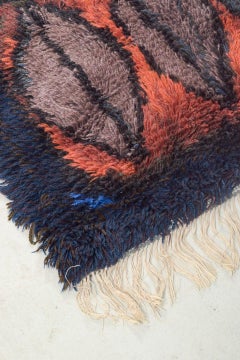Evy Viola Wiklund. Hand-knotted rya carpet in warm red, black, and blue tones.