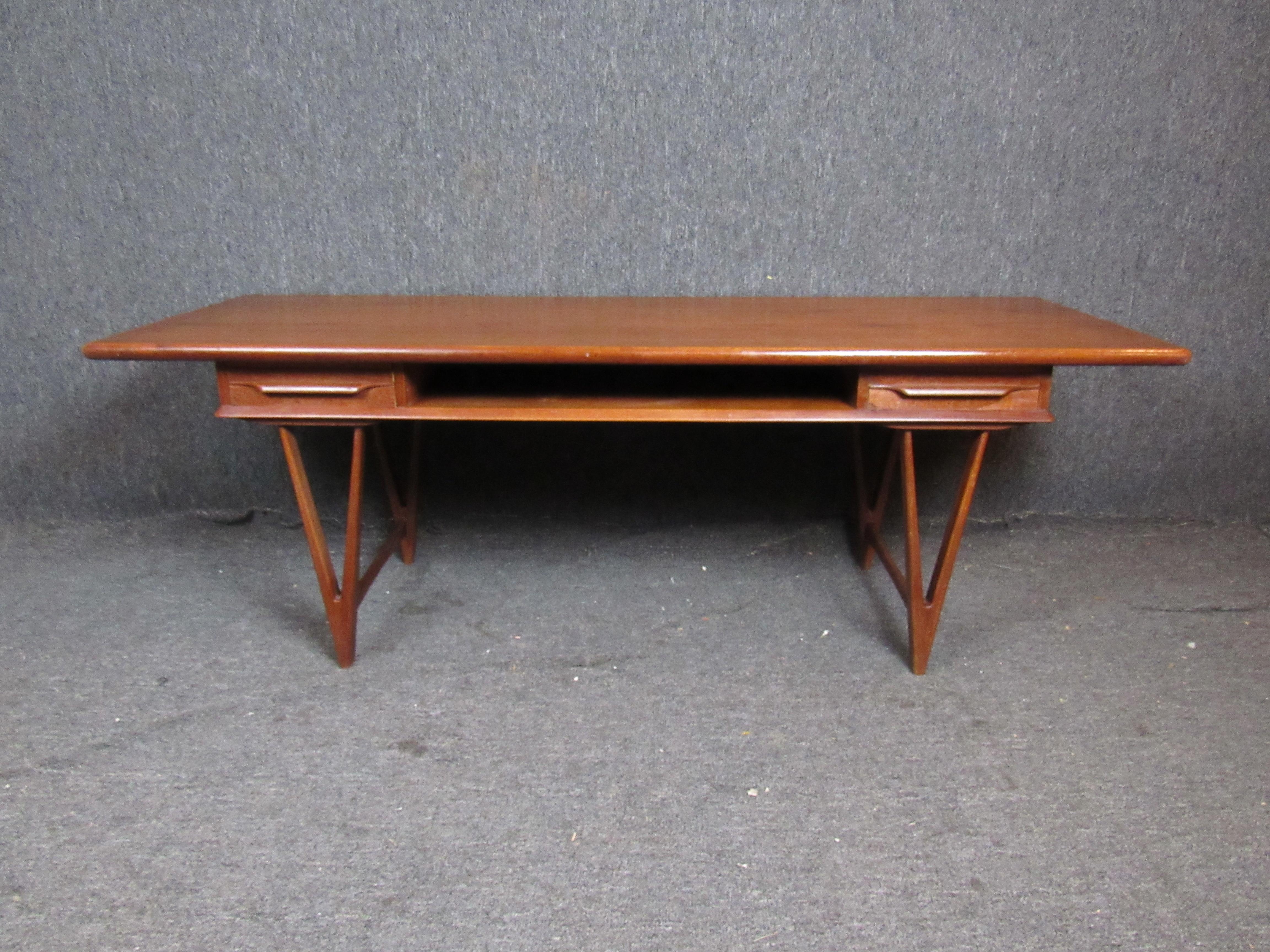 Danish made double side coffee table by E.W. Bach. Set on sleek V-shape legs, the top features a magazine shelf and two double side drawers.
Please confirm location NY or NJ