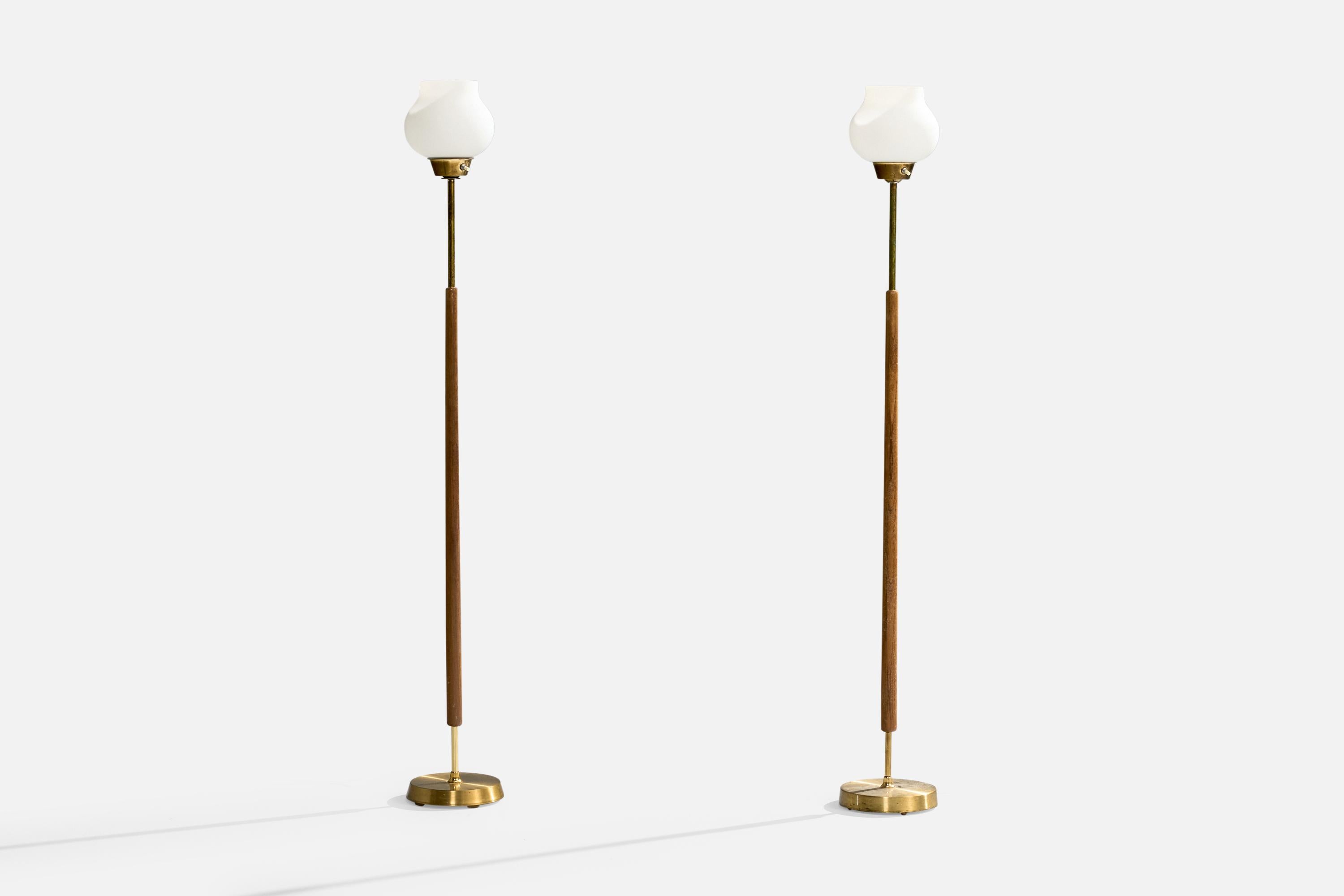 A pair of brass, teak and white opaline glass floor lamps produced by EWÅ Värnamo, Sweden, c. 1960s.

Dramatic patina present. Assorted vintage diffusers.

Dimensions of Lamp with Shade (inches): 51.2” H x 7“ Diameter

Bulb Specifications: E-26
